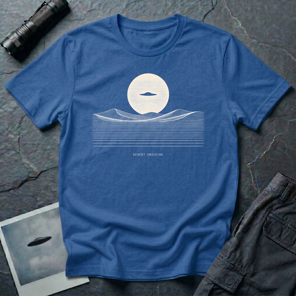 Desert Crossing UFO T-shirt with a black flying saucer crossing a white moon above minimalist line-art desert dunes, royal blue tee