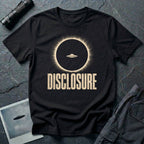 Black UFO disclosure t-shirt with a flying saucer silhouetted inside a total solar eclipse with radiant corona and the word DISCLOSURE in distressed block letters