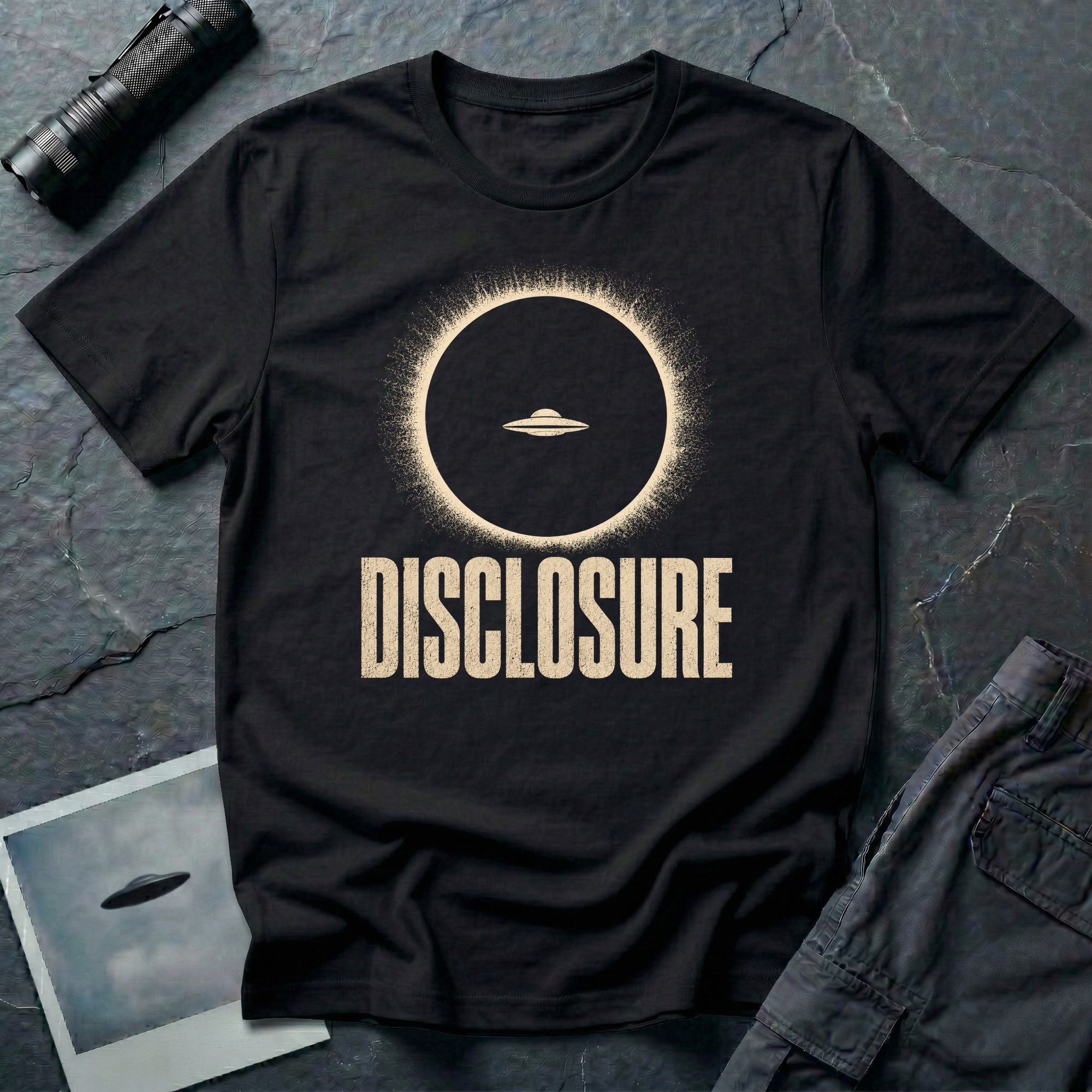 Black UFO disclosure t-shirt with a flying saucer silhouetted inside a total solar eclipse with radiant corona and the word DISCLOSURE in distressed block letters