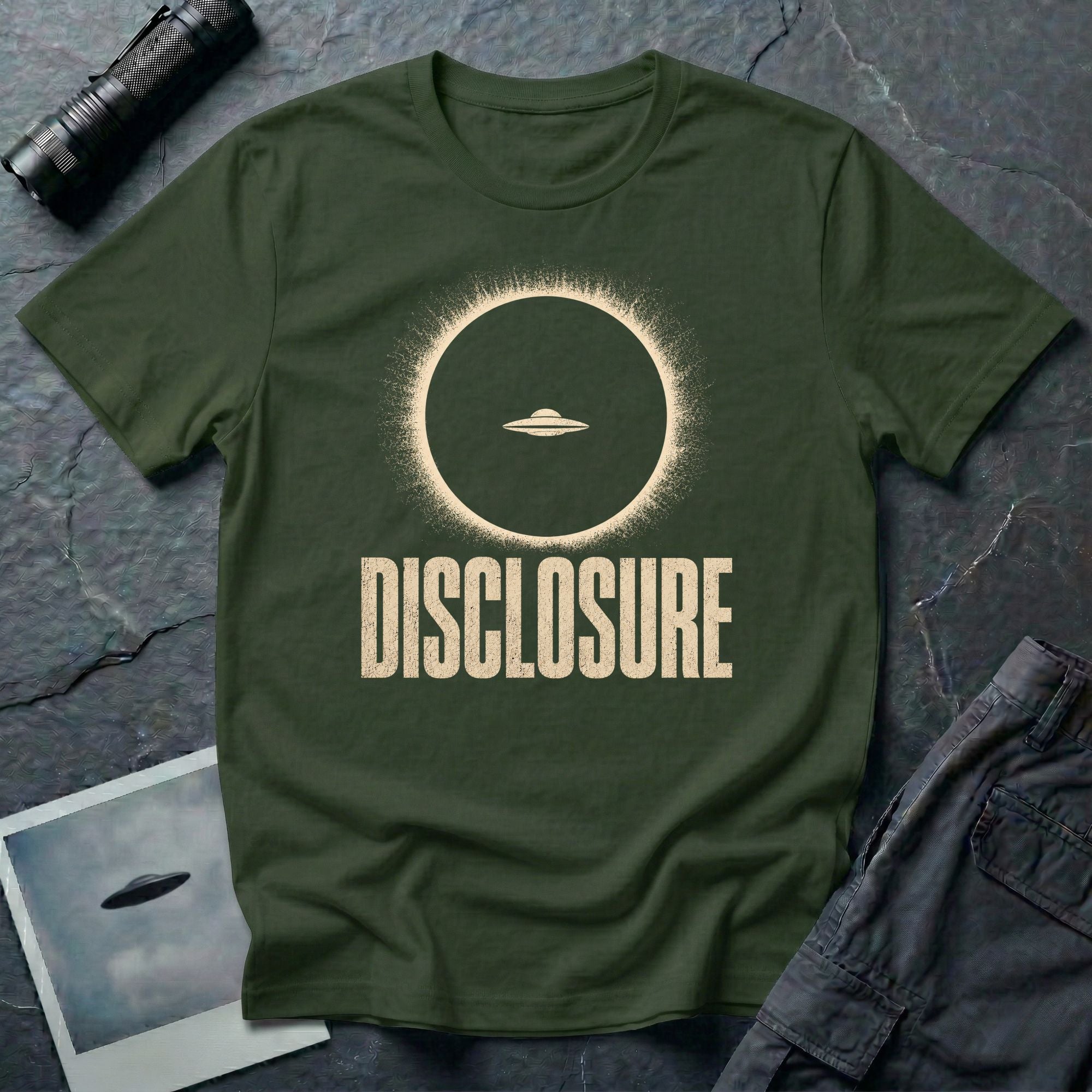 Green UFO disclosure t-shirt with a flying saucer silhouetted inside a total solar eclipse with radiant corona and the word DISCLOSURE in distressed block letters