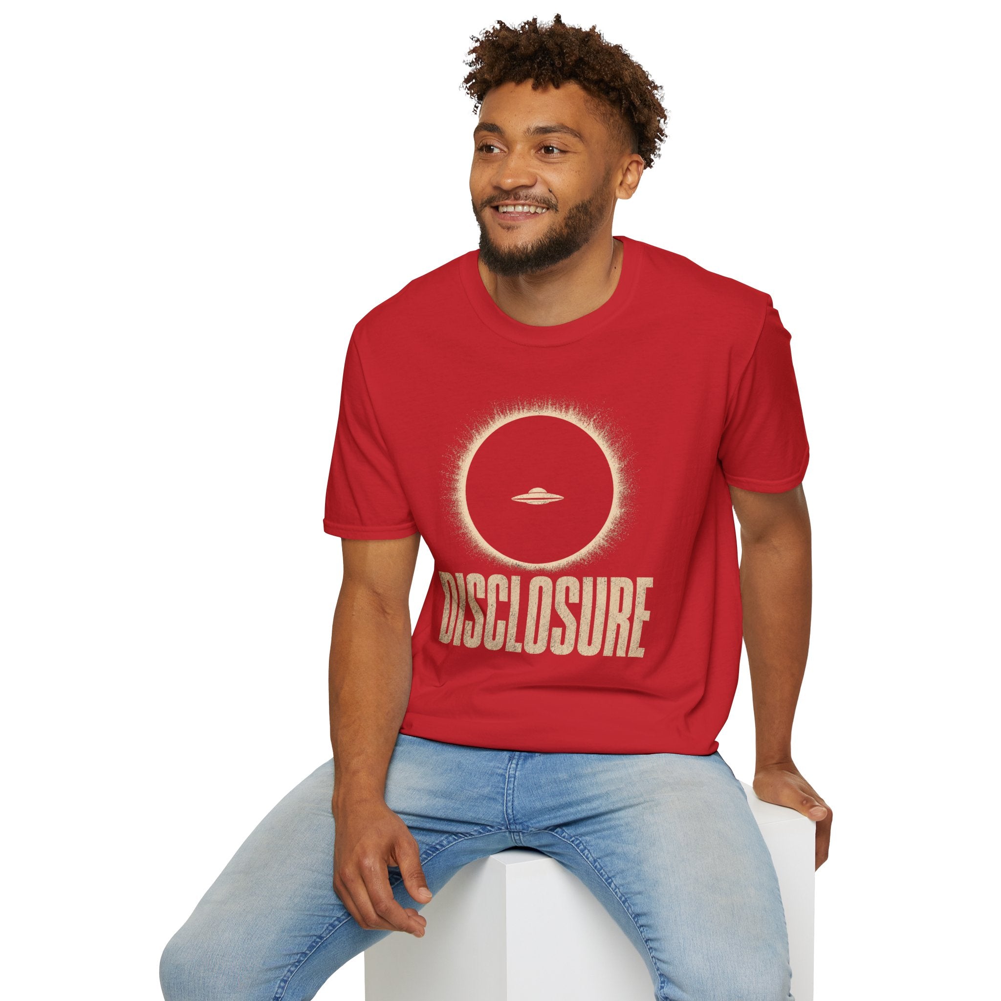 Man wearing red UFO disclosure t-shirt with a flying saucer silhouetted inside a total solar eclipse with radiant corona and the word DISCLOSURE in distressed block letters