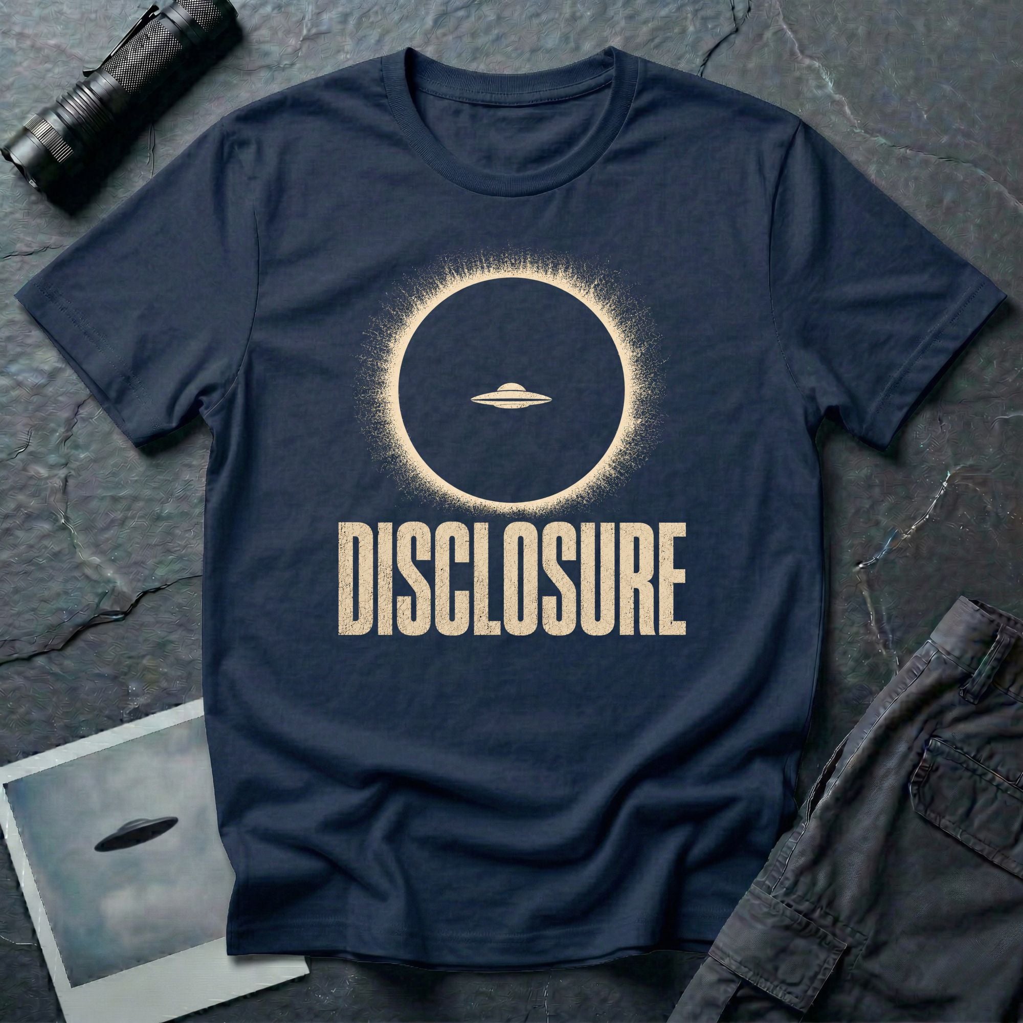 Navy blue UFO disclosure t-shirt with a flying saucer silhouetted inside a total solar eclipse with radiant corona and the word DISCLOSURE in distressed block letters