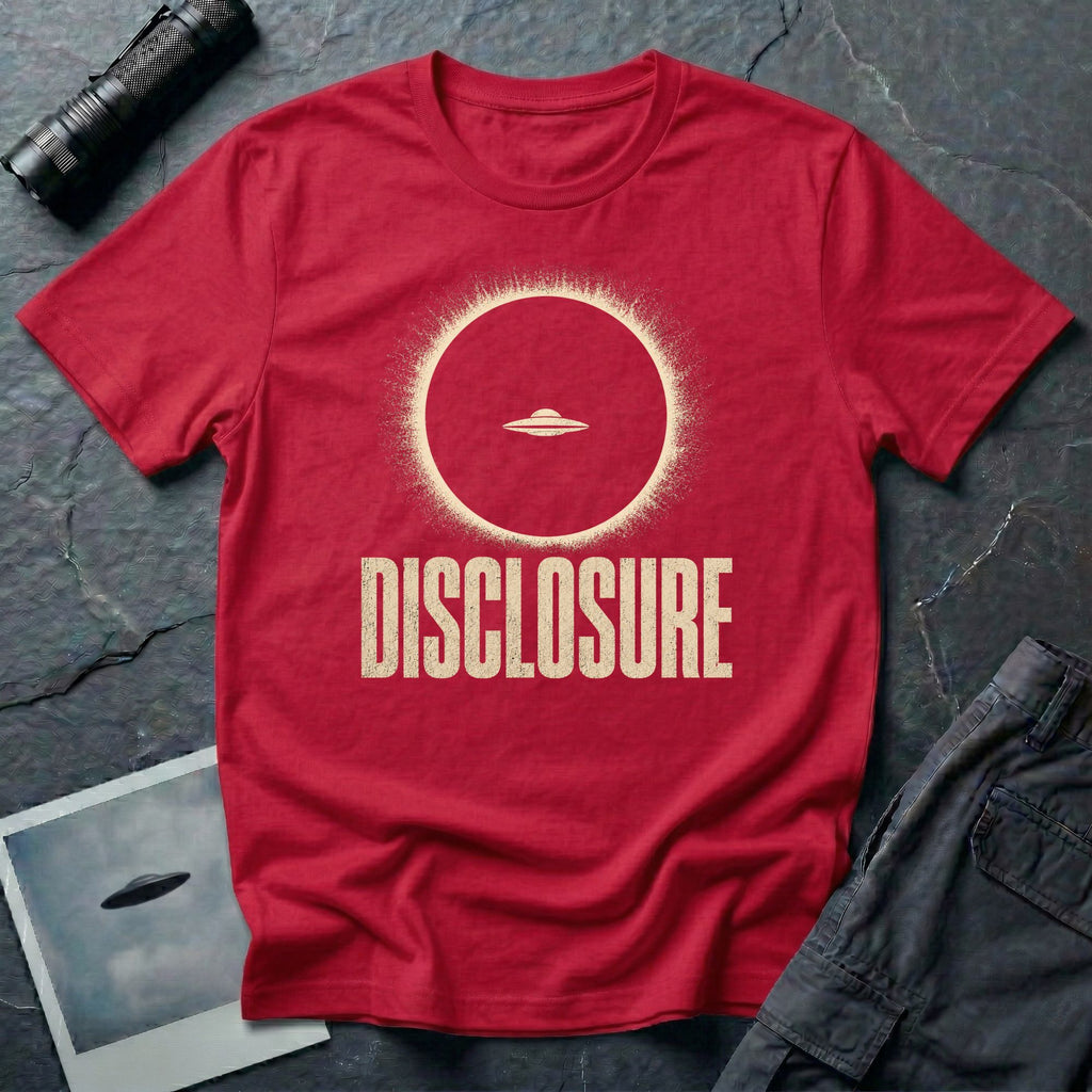 Red UFO disclosure t-shirt with a flying saucer silhouetted inside a total solar eclipse with radiant corona and the word DISCLOSURE in distressed block letters