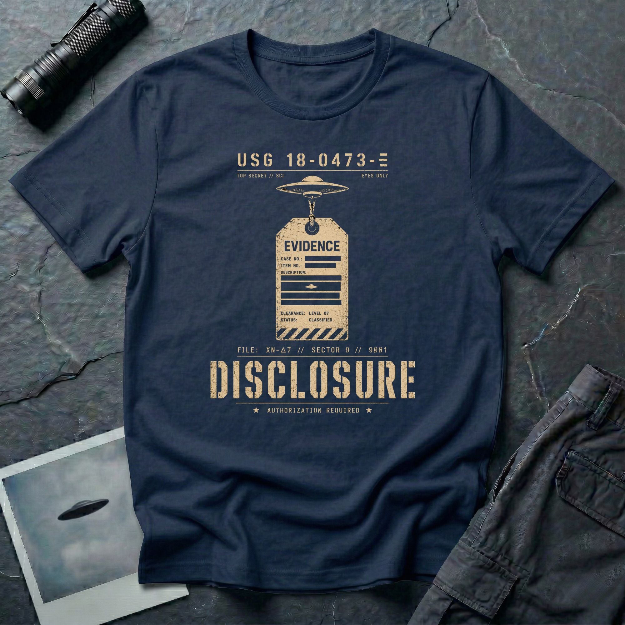 Navy blue UFO disclosure t-shirt with a classified evidence tag hanging from a flying saucer showing TOP SECRET SCI EYES ONLY and the word DISCLOSURE in distressed stencil type