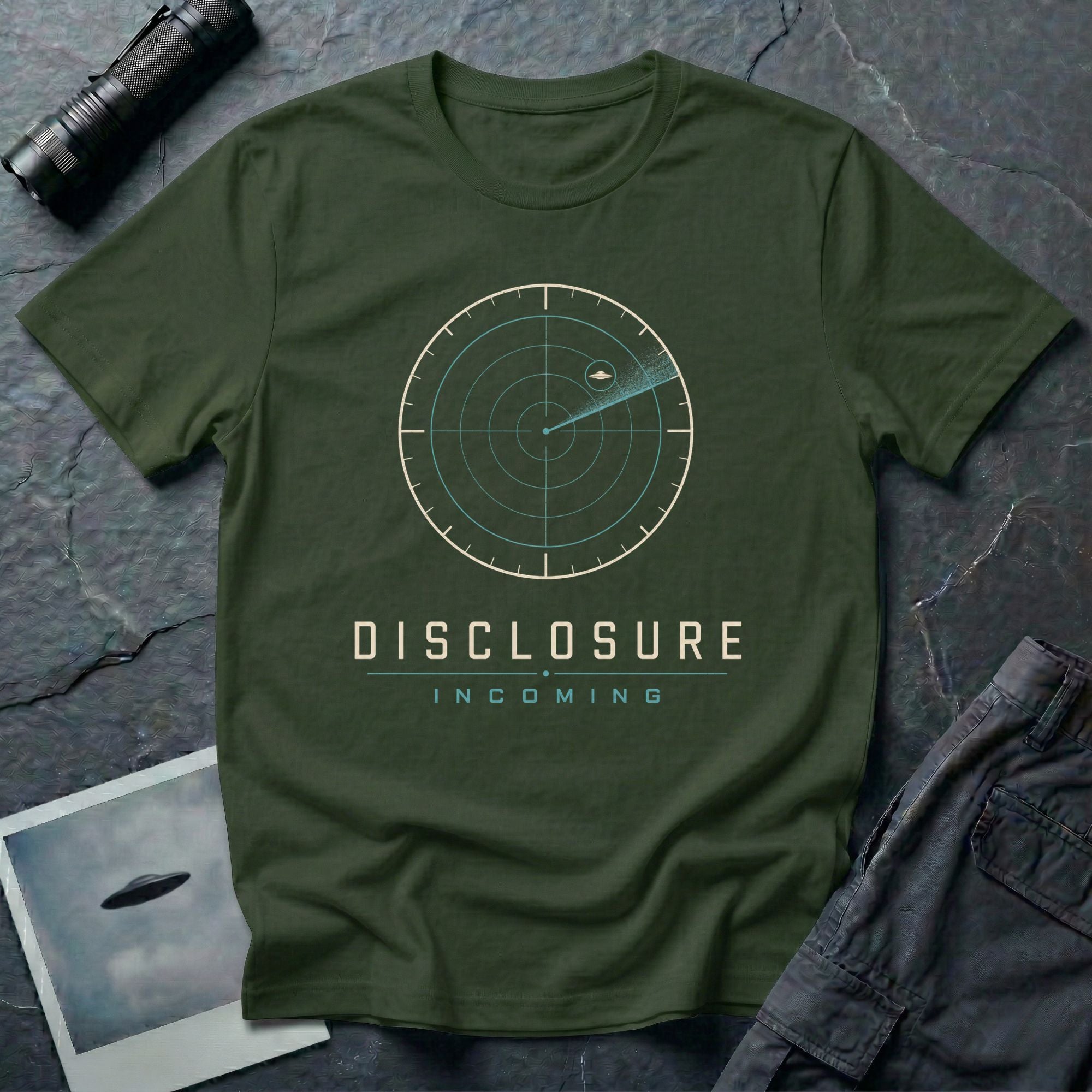 Green UFO disclosure t-shirt with a classic radar screen showing a flying saucer tracked in the upper quadrant with a sweep trail and the words DISCLOSURE INCOMING in cream and cyan