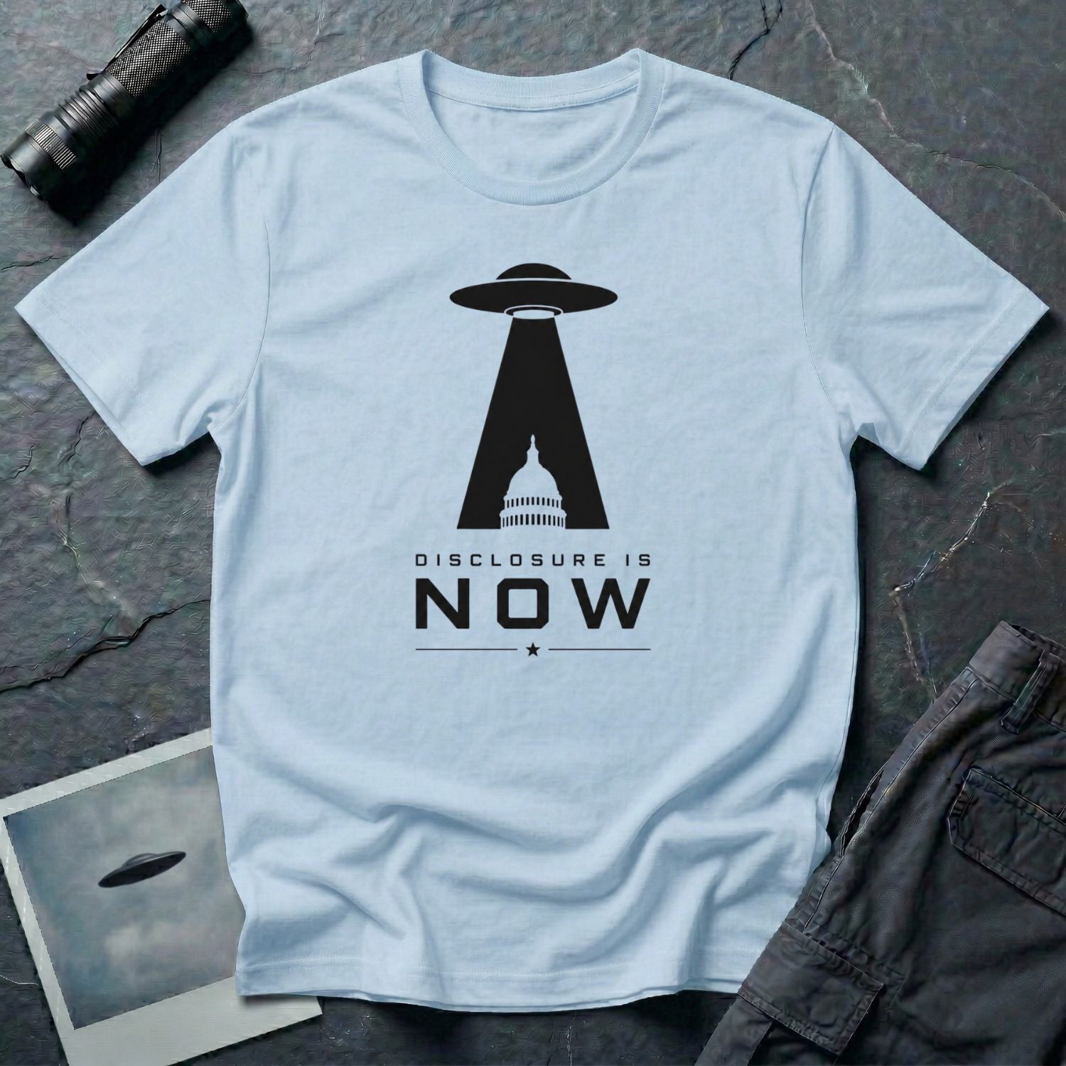Light blue UFO disclosure t-shirt with a flying saucer beaming the US Capitol building in black with the words DISCLOSURE IS NOW