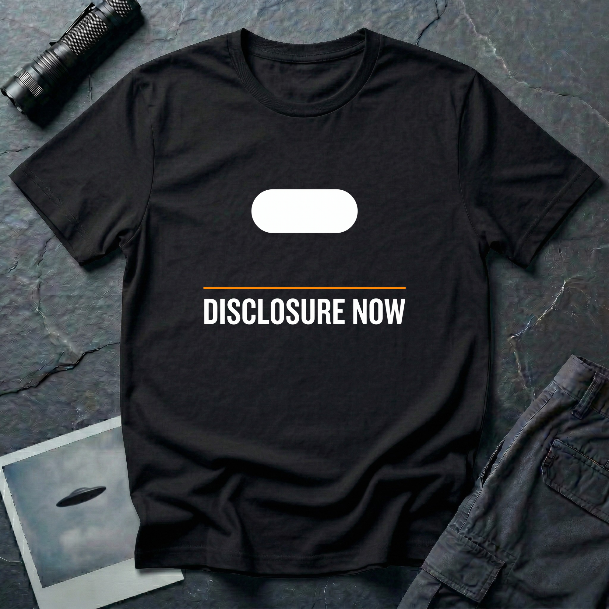 Black t-shirt with white Tic Tac UAP silhouette above an orange horizontal rule and DISCLOSURE NOW in bold white caps