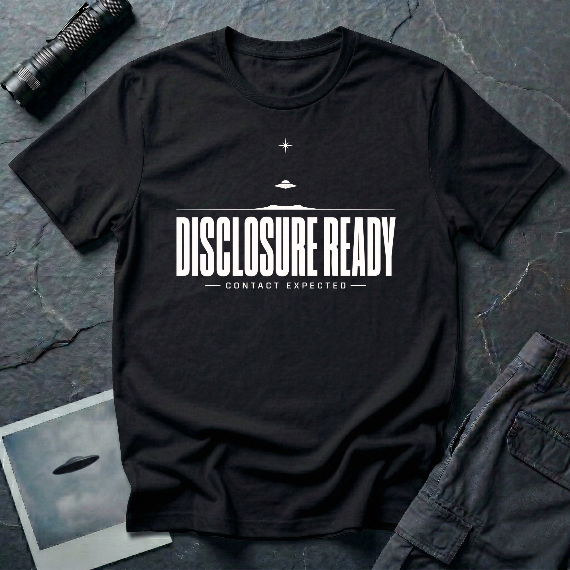 Black UFO disclosure t-shirt with bold block letters reading DISCLOSURE READY and subtitle CONTACT EXPECTED with a small flying saucer above the horizon in white