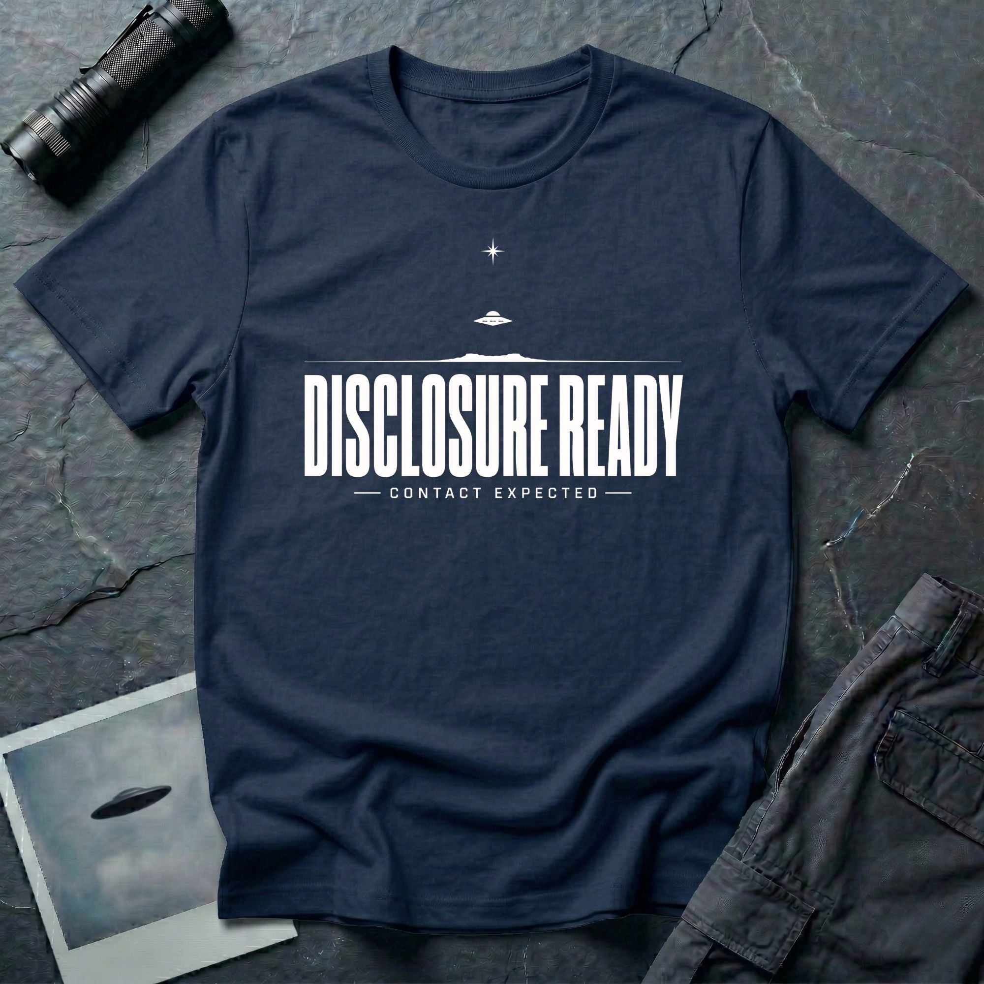 Navy blue UFO disclosure t-shirt with bold block letters reading DISCLOSURE READY and subtitle CONTACT EXPECTED with a small flying saucer above the horizon in white
