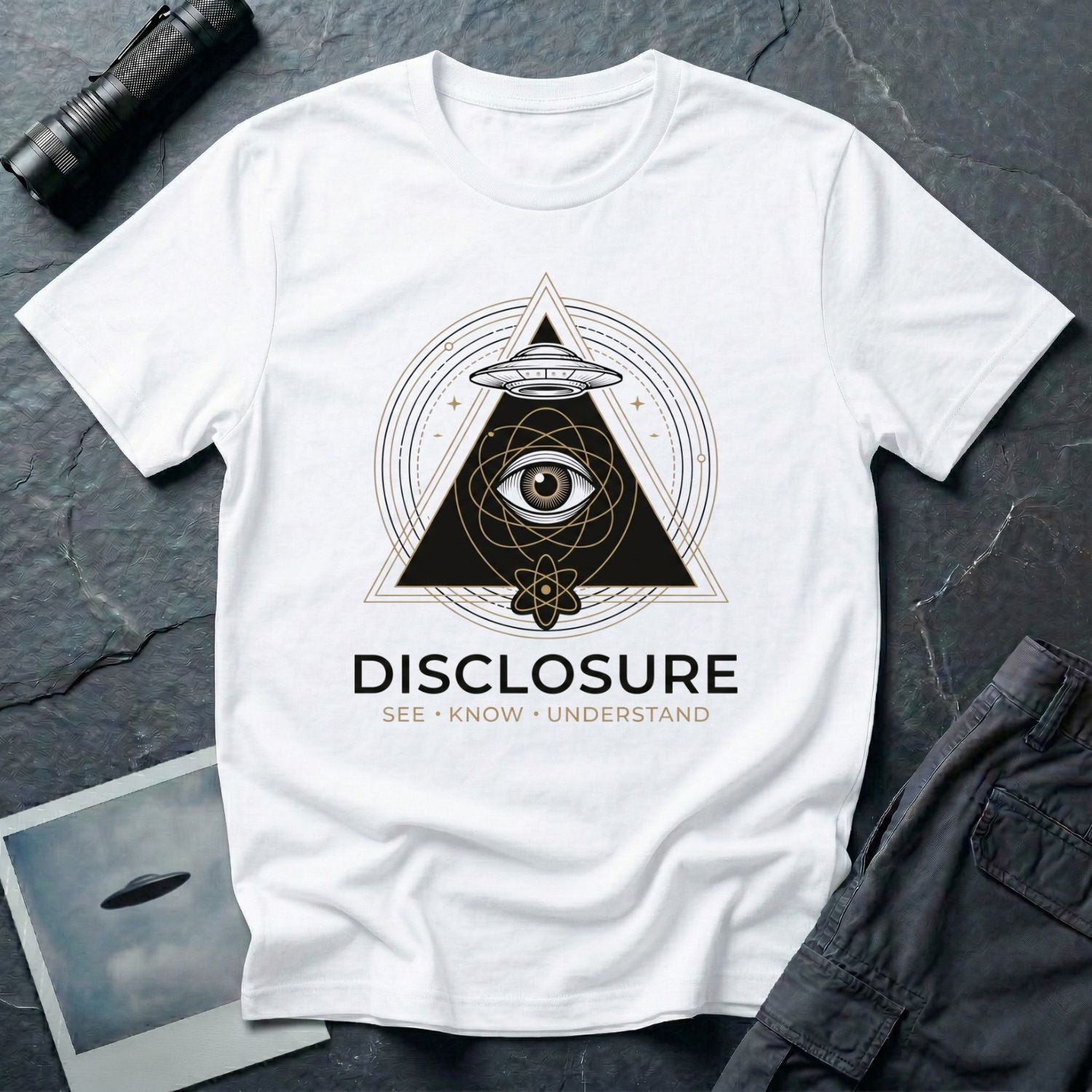 White UFO disclosure t-shirt with an all-seeing eye inside a triangle, flying saucer above, atomic symbol below, and the words DISCLOSURE SEE KNOW UNDERSTAND