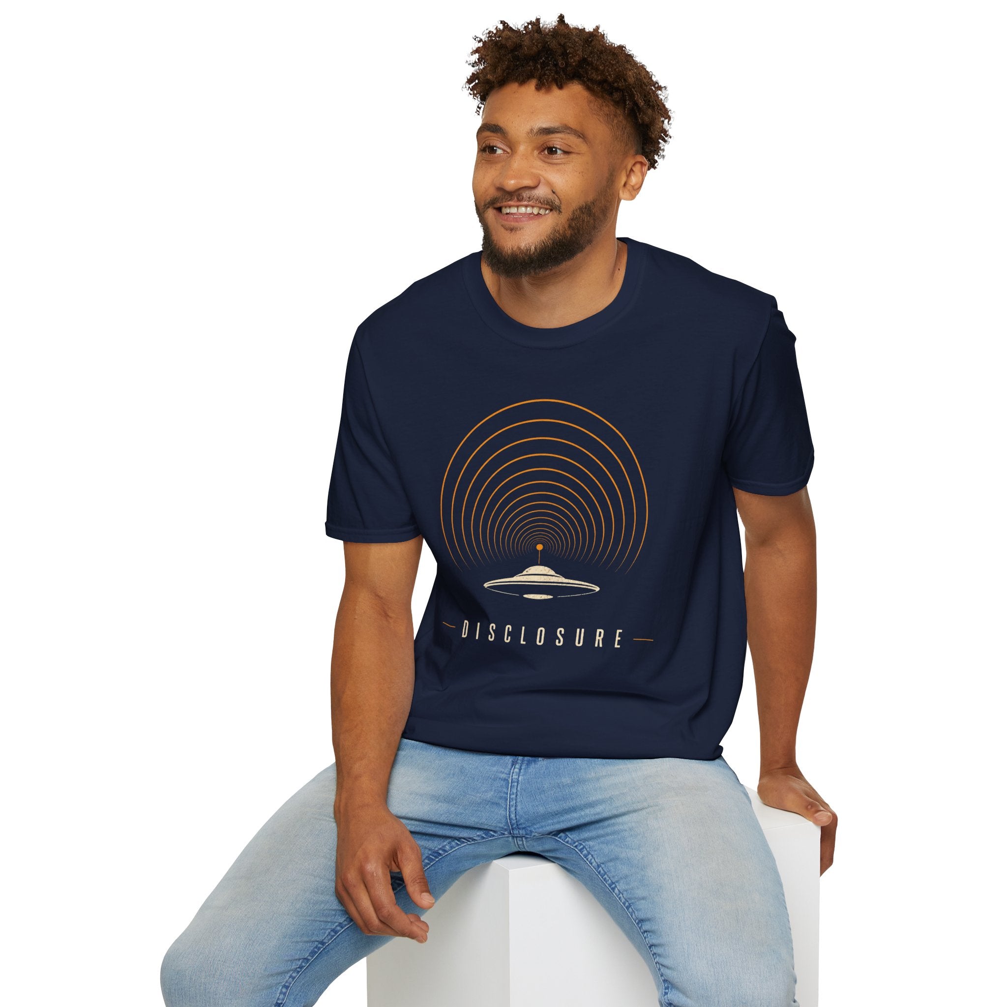 Man wearing navy blue UFO disclosure t-shirt with a flying saucer broadcasting concentric signal arcs upward in orange and cream with the word DISCLOSURE beneath