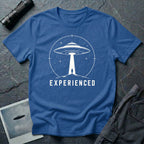 Experienced UFO T-shirt with a lone figure standing beneath the beam of a flying saucer inside a circular night-sky design. Royal blue tee