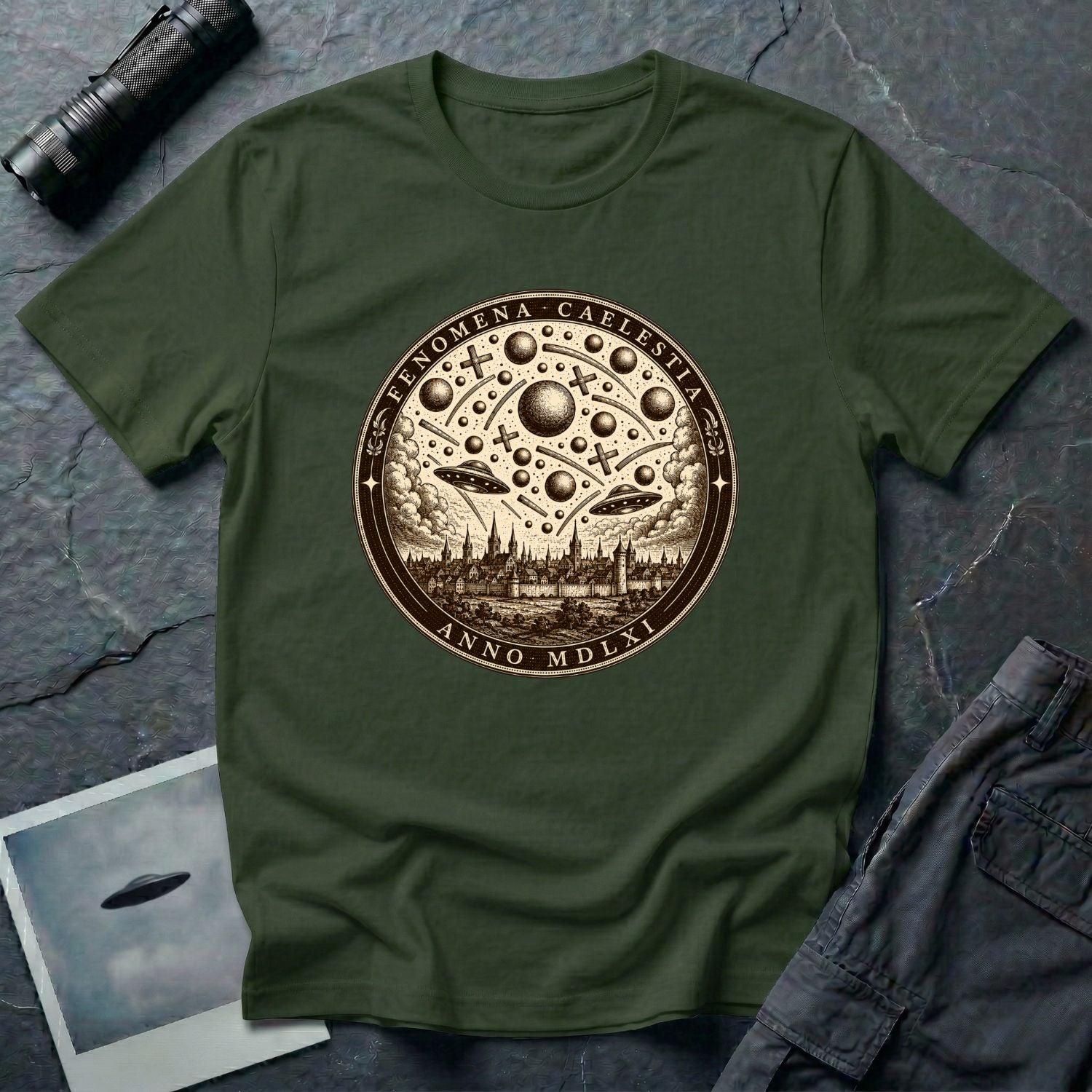 Military green t-shirt with a sepia engraving medallion depicting the 1561 Nuremberg UFO phenomenon with craft, spheres and the words FENOMENA CAELESTIA ANNO MDLXI