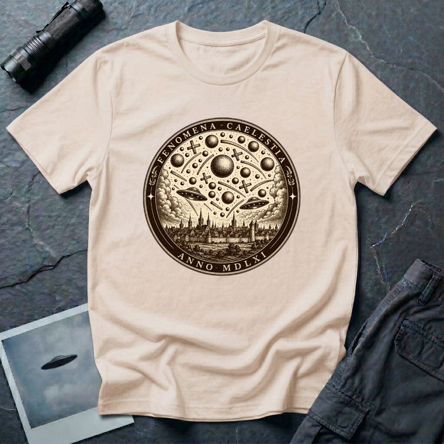 Natural coloured t-shirt with a sepia engraving medallion depicting the 1561 Nuremberg UFO phenomenon with craft, spheres and the words FENOMENA CAELESTIA ANNO MDLXI
