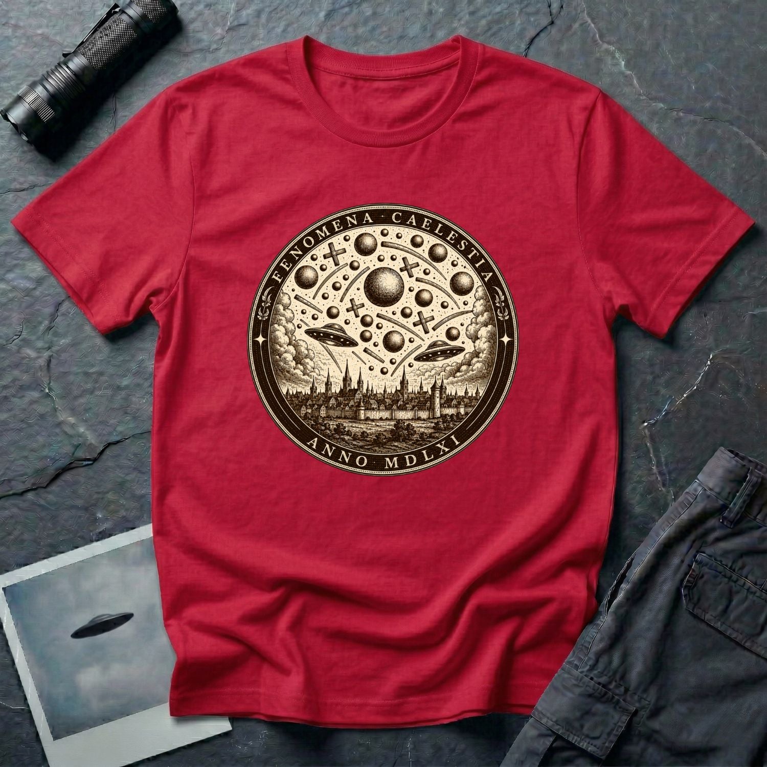 Red t-shirt with a sepia engraving medallion depicting the 1561 Nuremberg UFO phenomenon with craft, spheres and the words FENOMENA CAELESTIA ANNO MDLXI