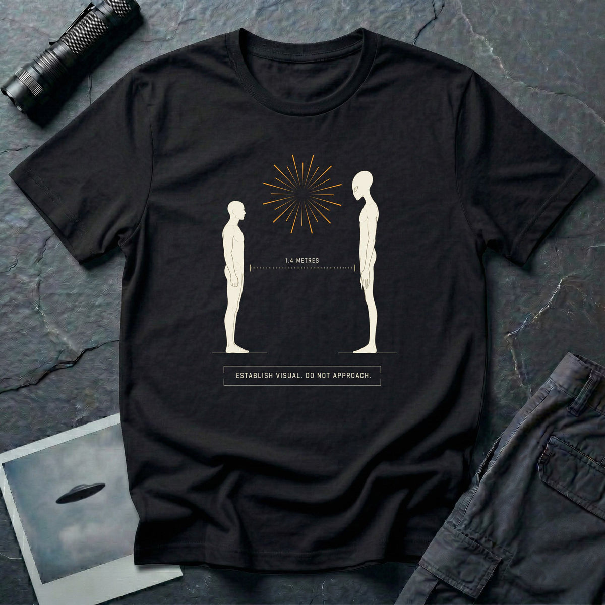 Black t-shirt with human and alien figures facing each other at a measured 1.4 metre distance under a starburst, with establish visual do not approach caption