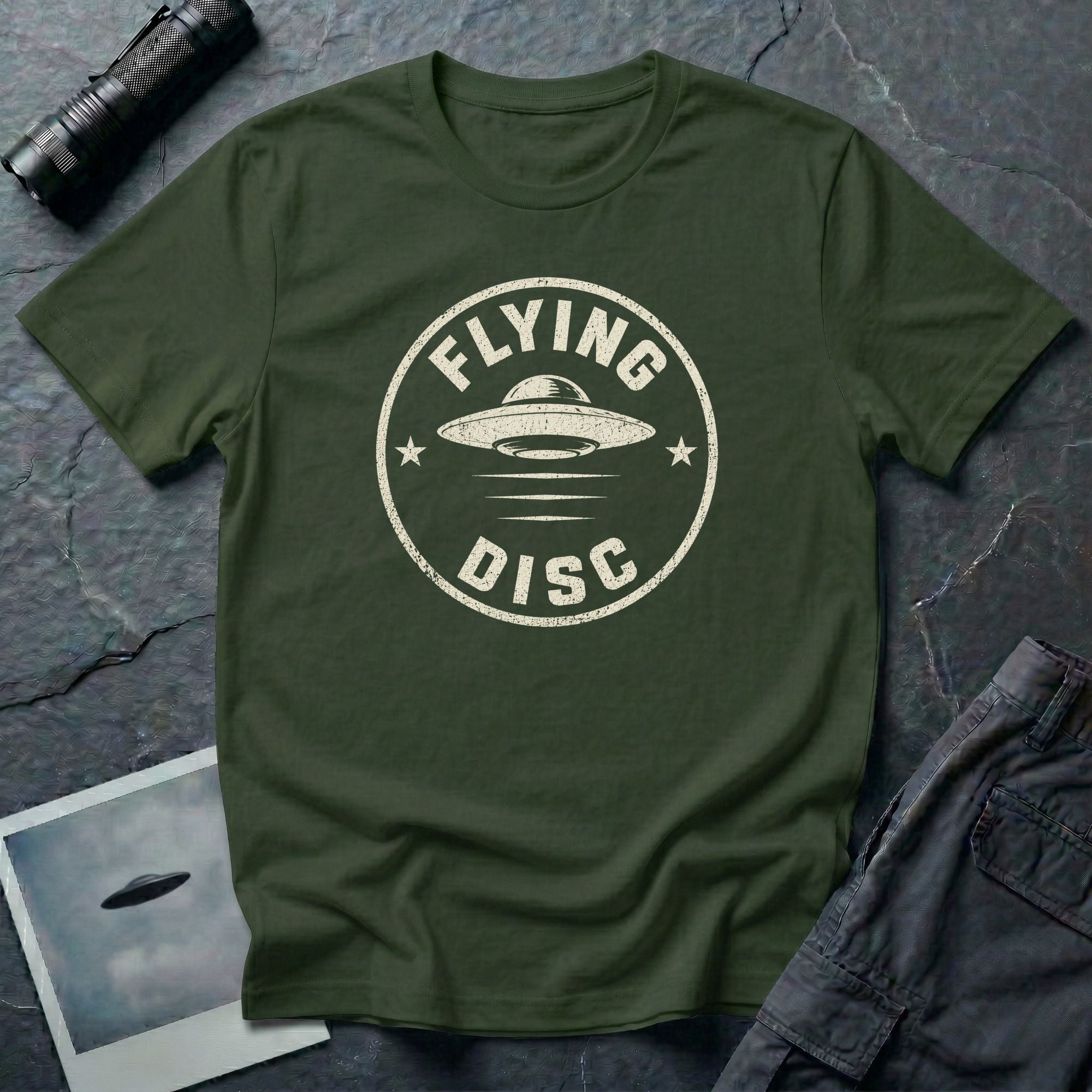 Military green retro UFO t-shirt with a distressed circular badge design featuring a flying saucer and the words FLYING DISC in white