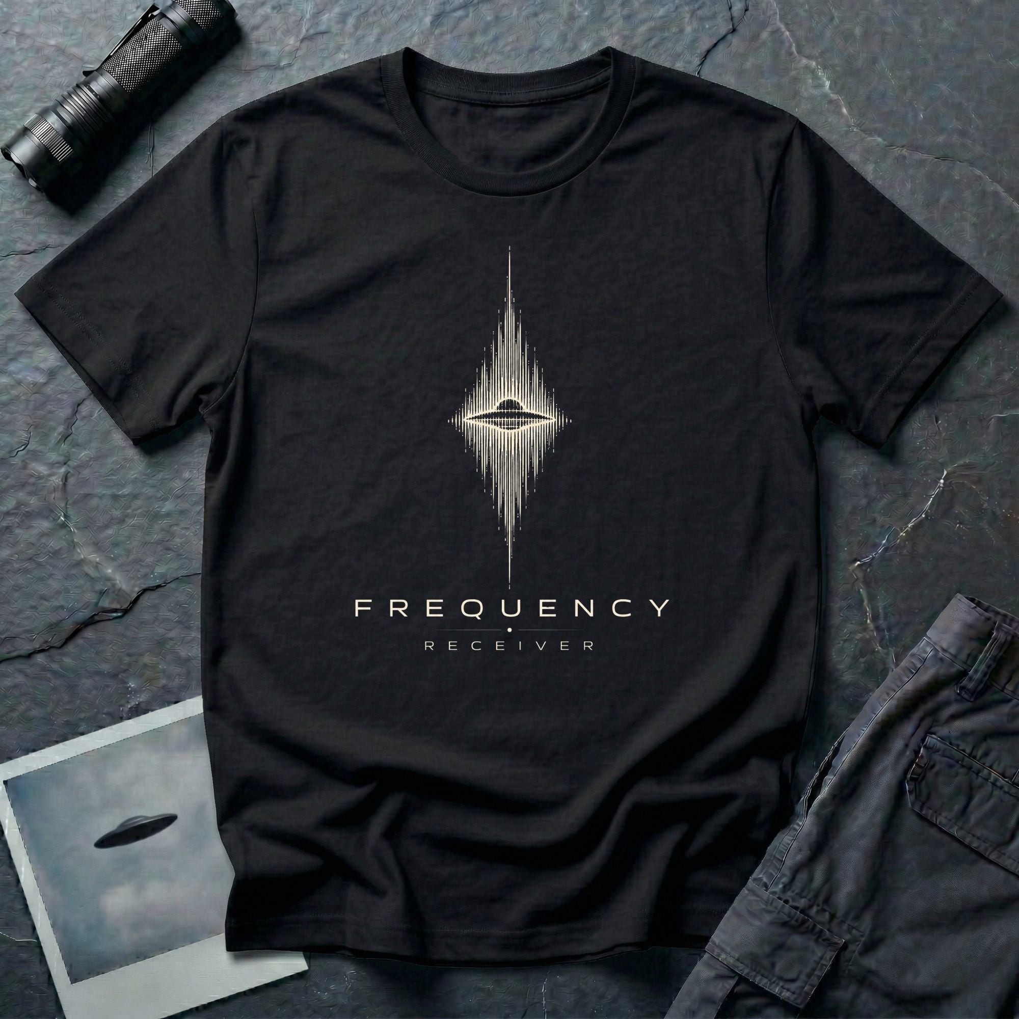 Black UFO t-shirt with a flying saucer at the centre of a diamond-shaped frequency waveform in cream with the words FREQUENCY RECEIVER beneath