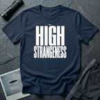 Navy blue t-shirt with bold white High Strangeness text and small UFO above the lettering