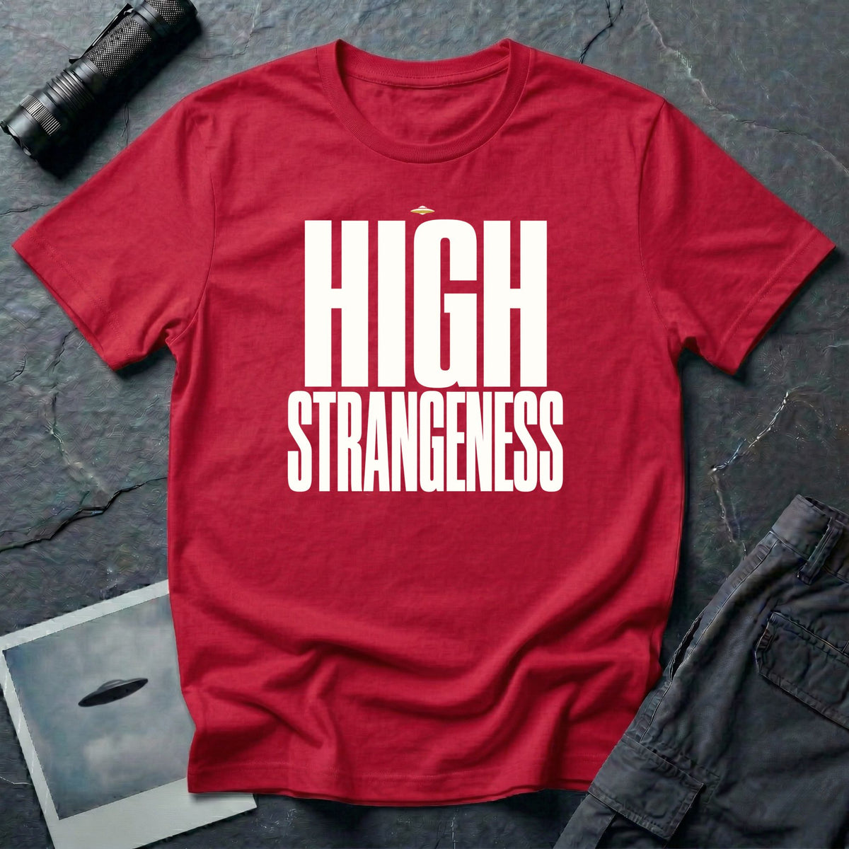 Red t-shirt with bold white High Strangeness text and small UFO above the lettering