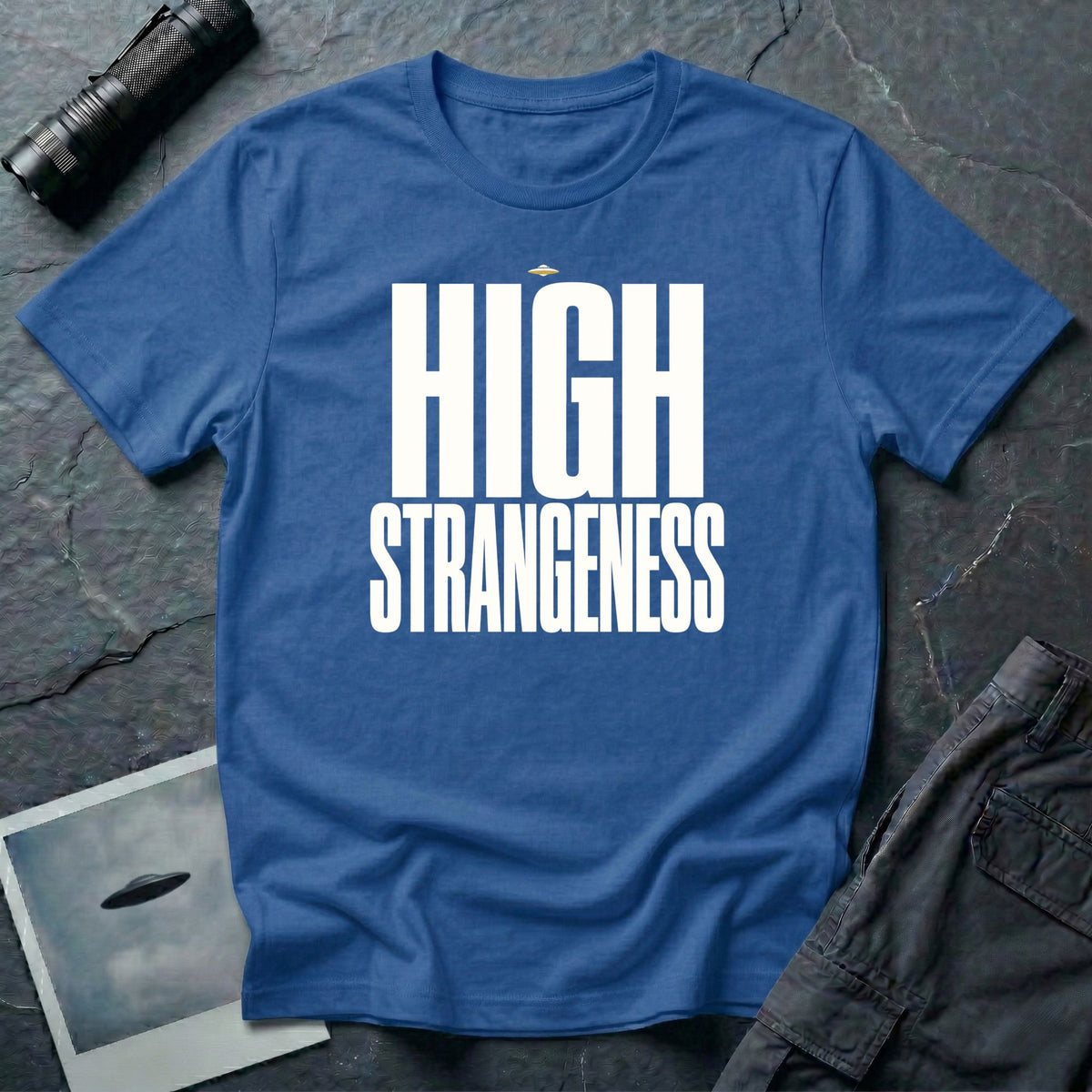Royal blue t-shirt with bold white High Strangeness text and small UFO above the lettering