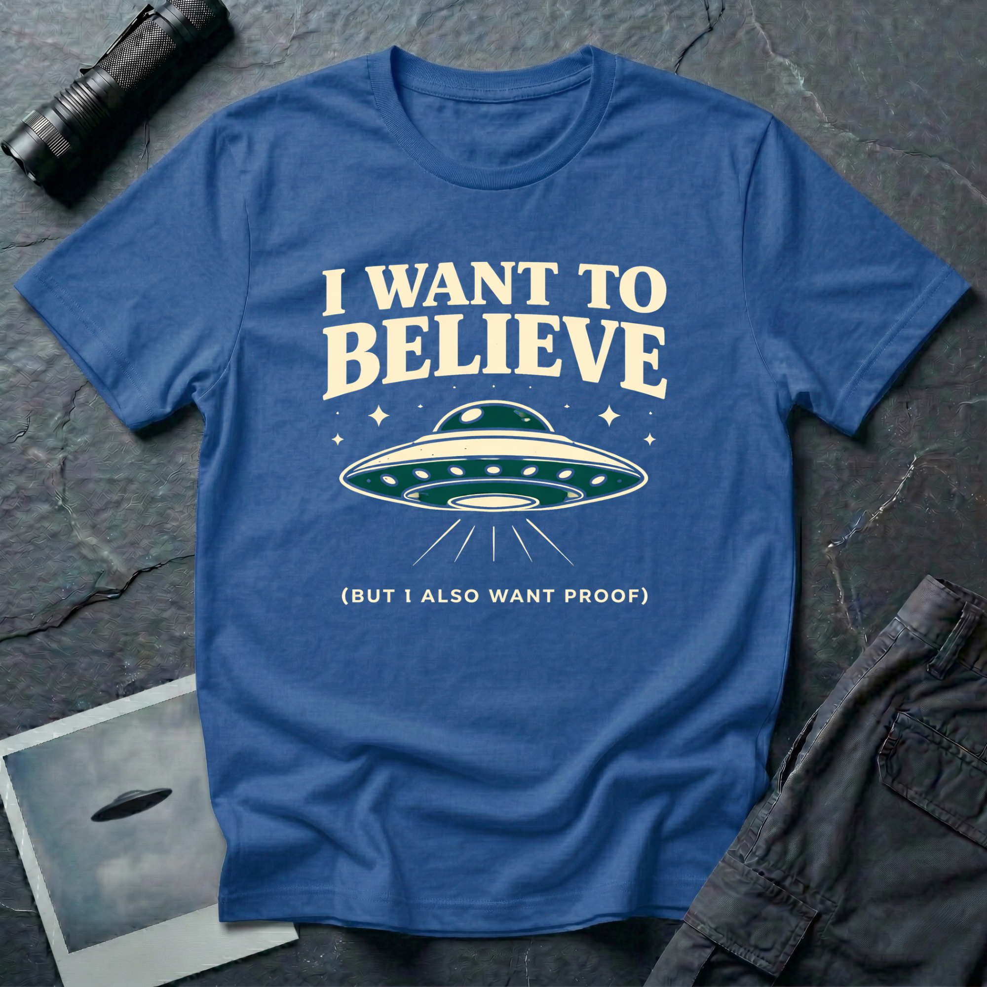 I Want To Believe ironic UFO t-shirt — classic teal saucer with the phrase "I want to believe (but I also want proof)" on blue cotton tee