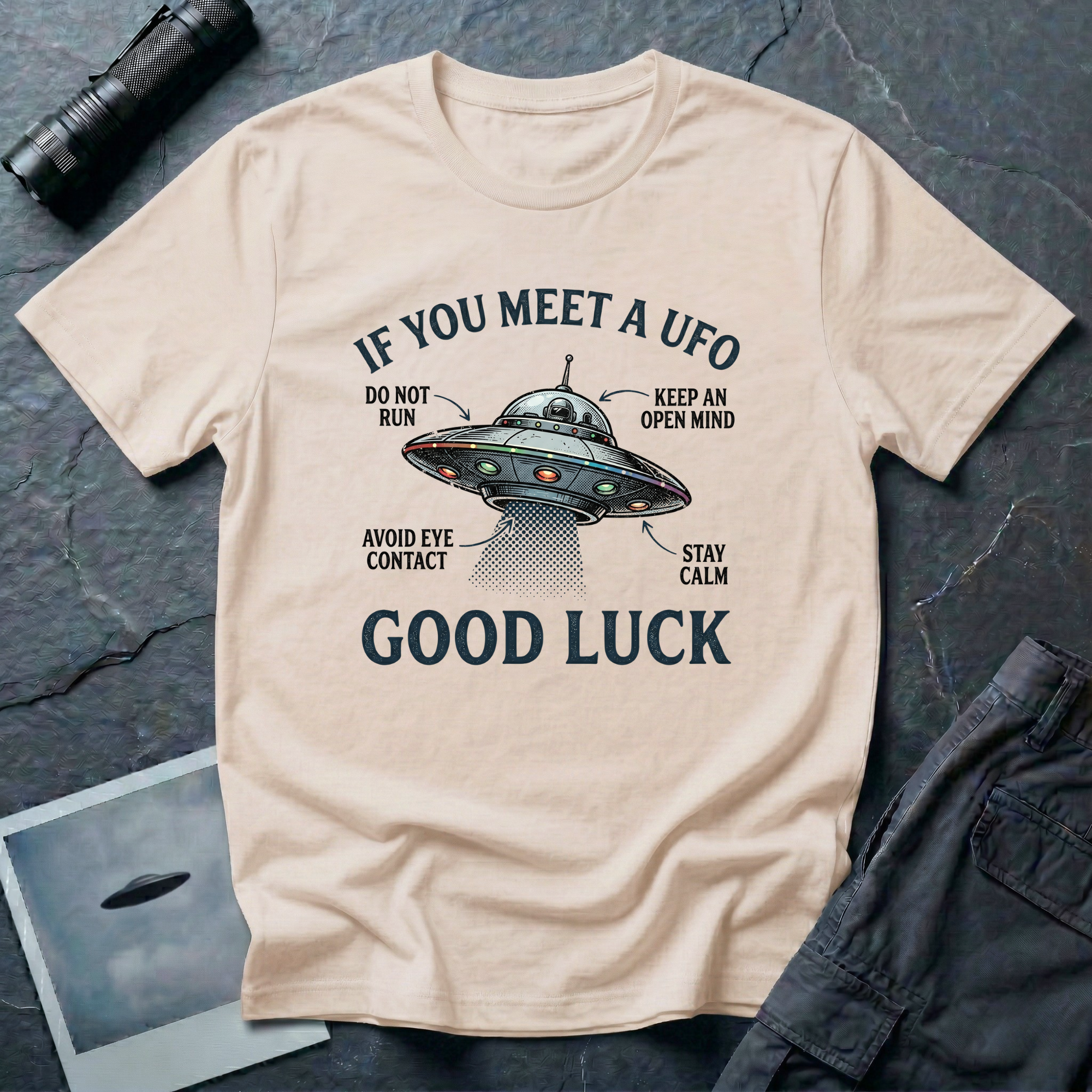 If You Meet A UFO funny UFO t-shirt — flying saucer with deadpan safety instructions on natural unisex cotton tee