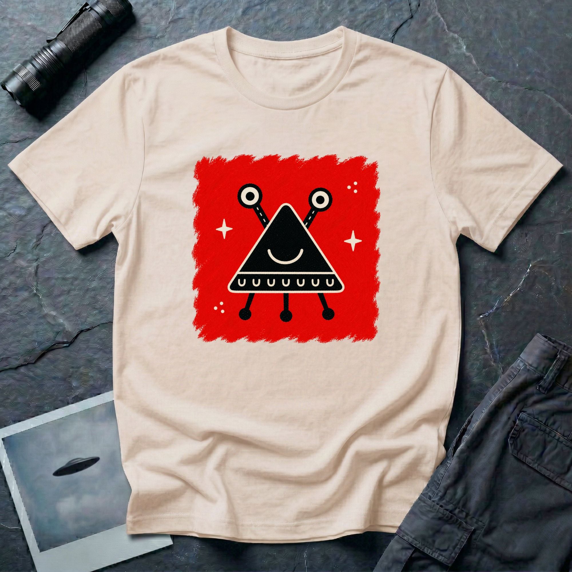 Little Visitors The Triangle UFO t-shirt with smiling black triangle craft on red, natural shirt