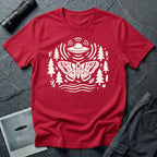 Moth and UFO T-shirt with a folk-art moth beneath a flying saucer, surrounded by pine trees, leaves and radiating signal lines, on red t-shirt