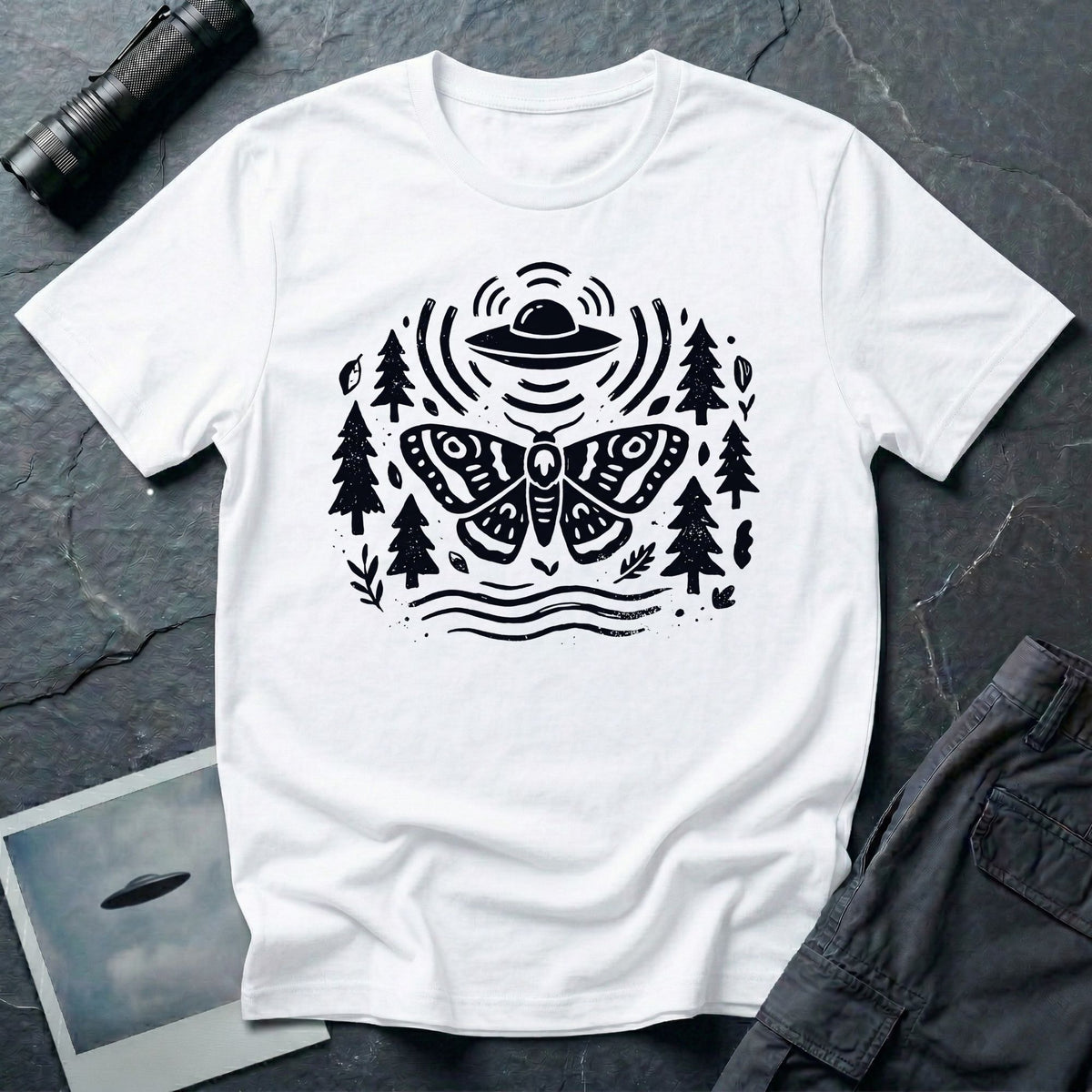 Moth and UFO T-shirt with a folk-art moth beneath a flying saucer, surrounded by pine trees, leaves and radiating signal lines, on white t-shirt