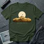 T-shirt with gold engraved mountain range under a moon and UFO with Mountain Return Cascades 1947 caption, military green