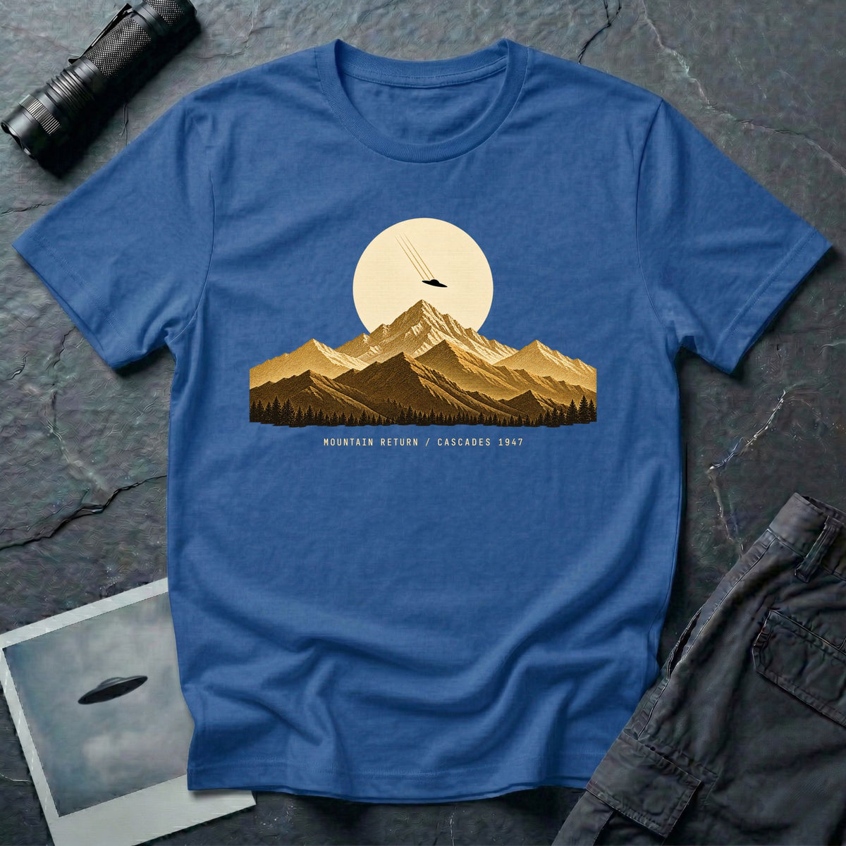 T-shirt with gold engraved mountain range under a moon and UFO with Mountain Return Cascades 1947 caption, royal blue