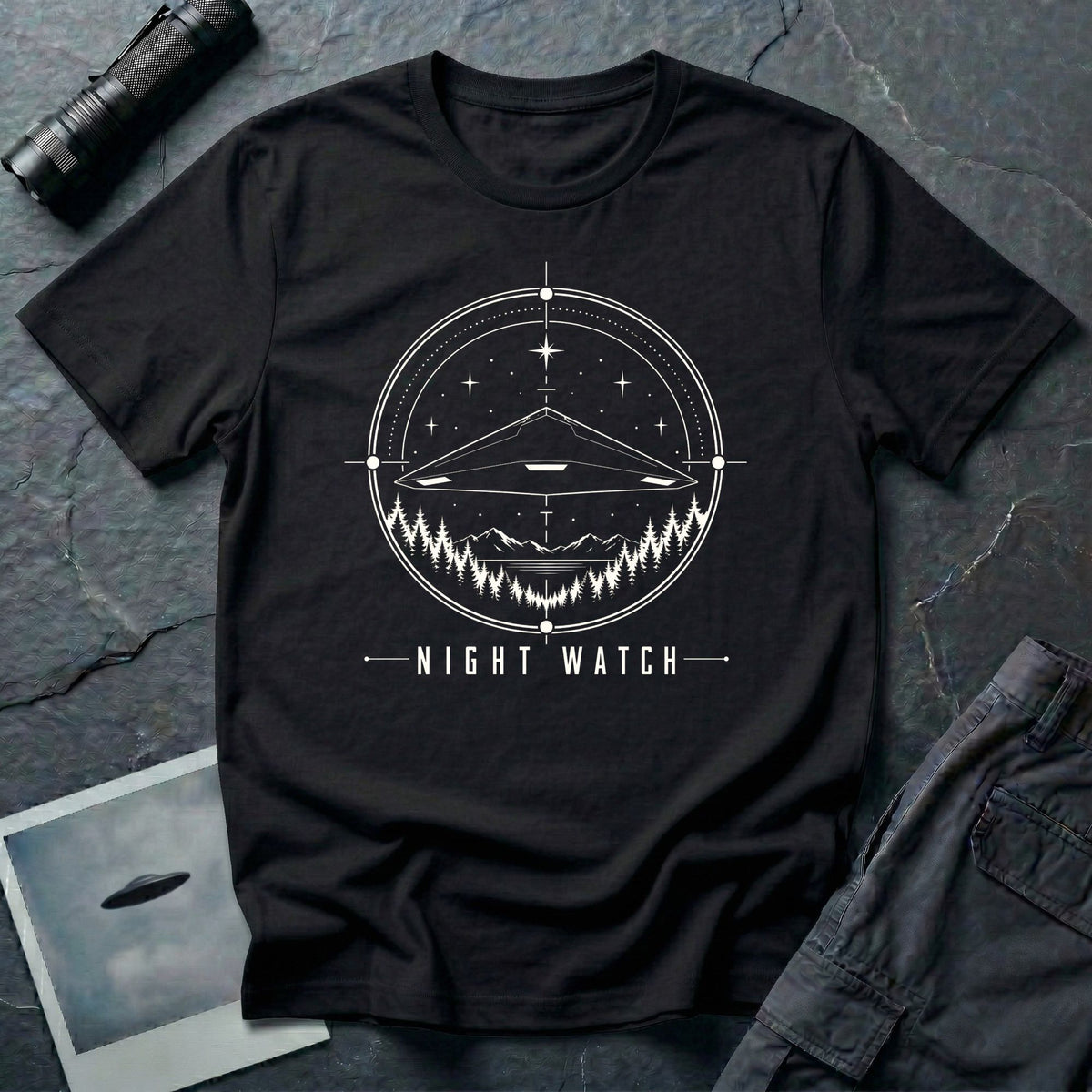 Night Watch UAP T-shirt with a black triangle craft hovering above a pine forest and mountains inside a celestial observation circle on black tee