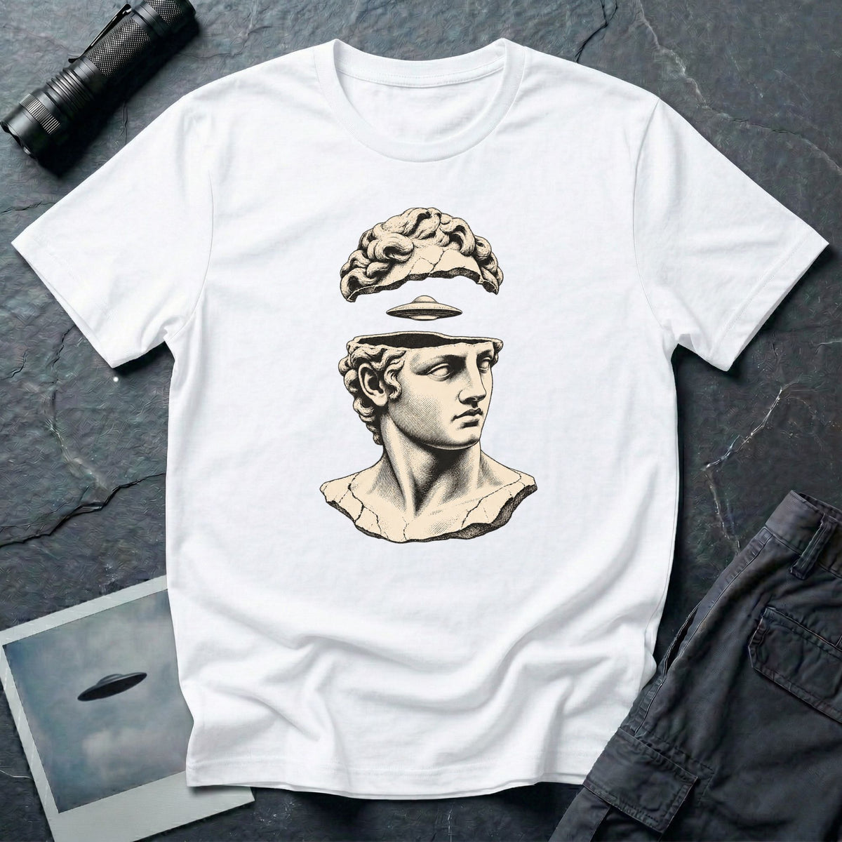 Classical marble bust with the top of the head lifted to reveal a UFO emerging, in cream engraving linework on a white t-shirt