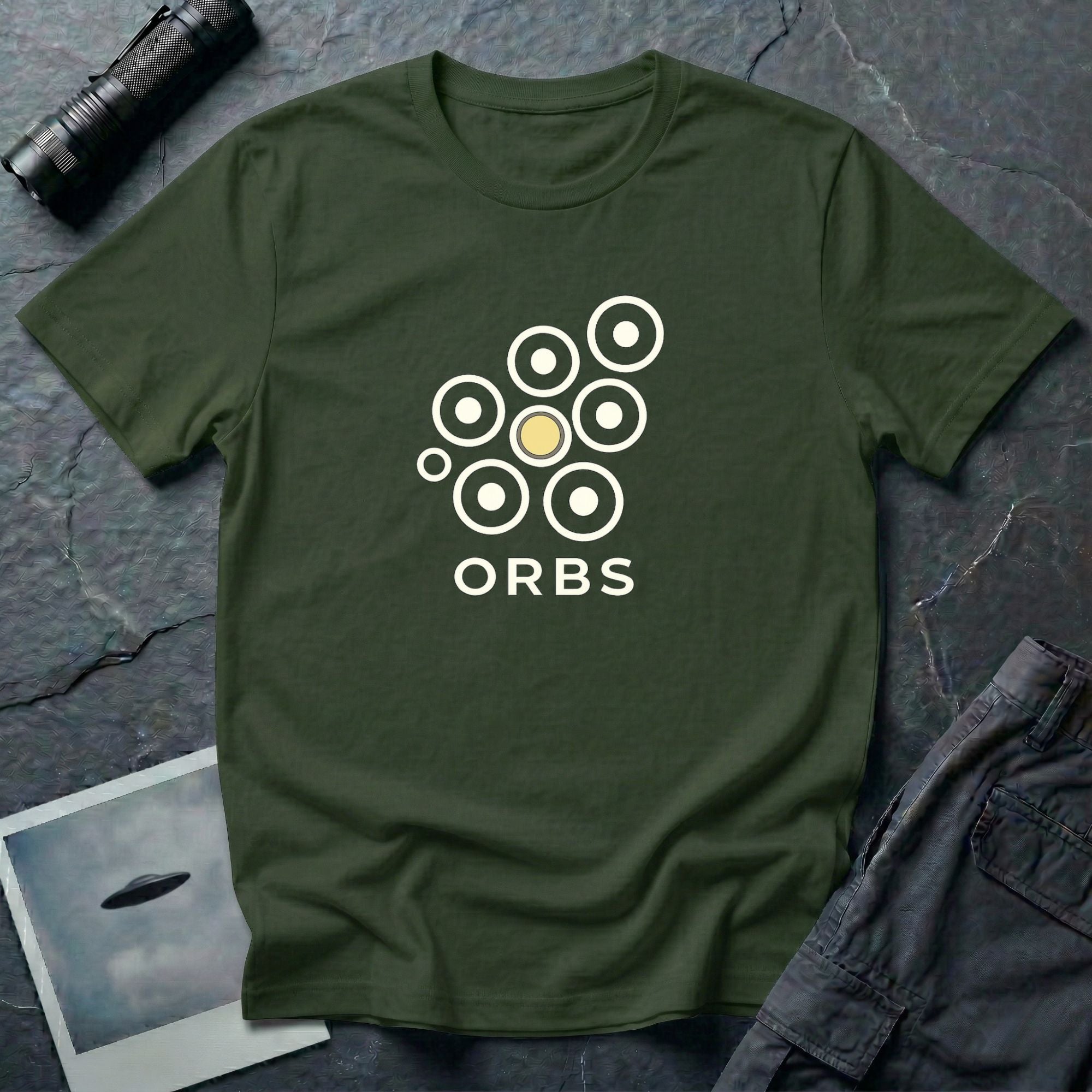 Orbs UFO t-shirt, seven ring-and-dot circles in a rosette pattern with one solid gold orb, above bold ORBS text, green