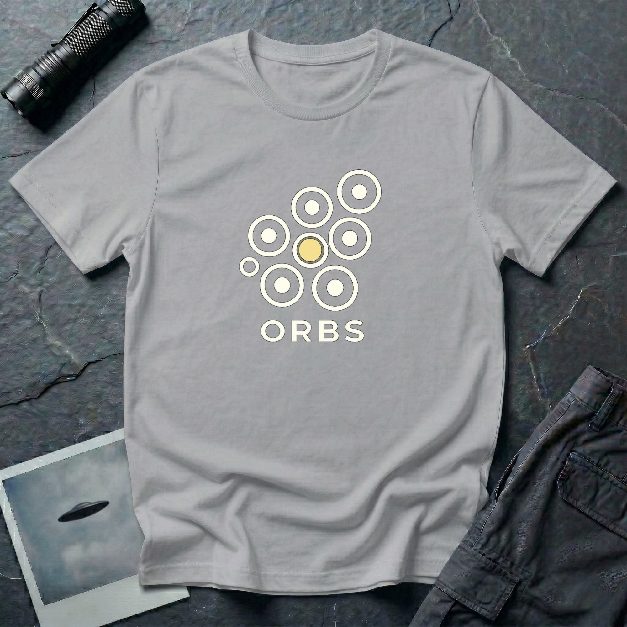 Orbs UFO t-shirt, seven ring-and-dot circles in a rosette pattern with one solid gold orb, above bold ORBS text, grey