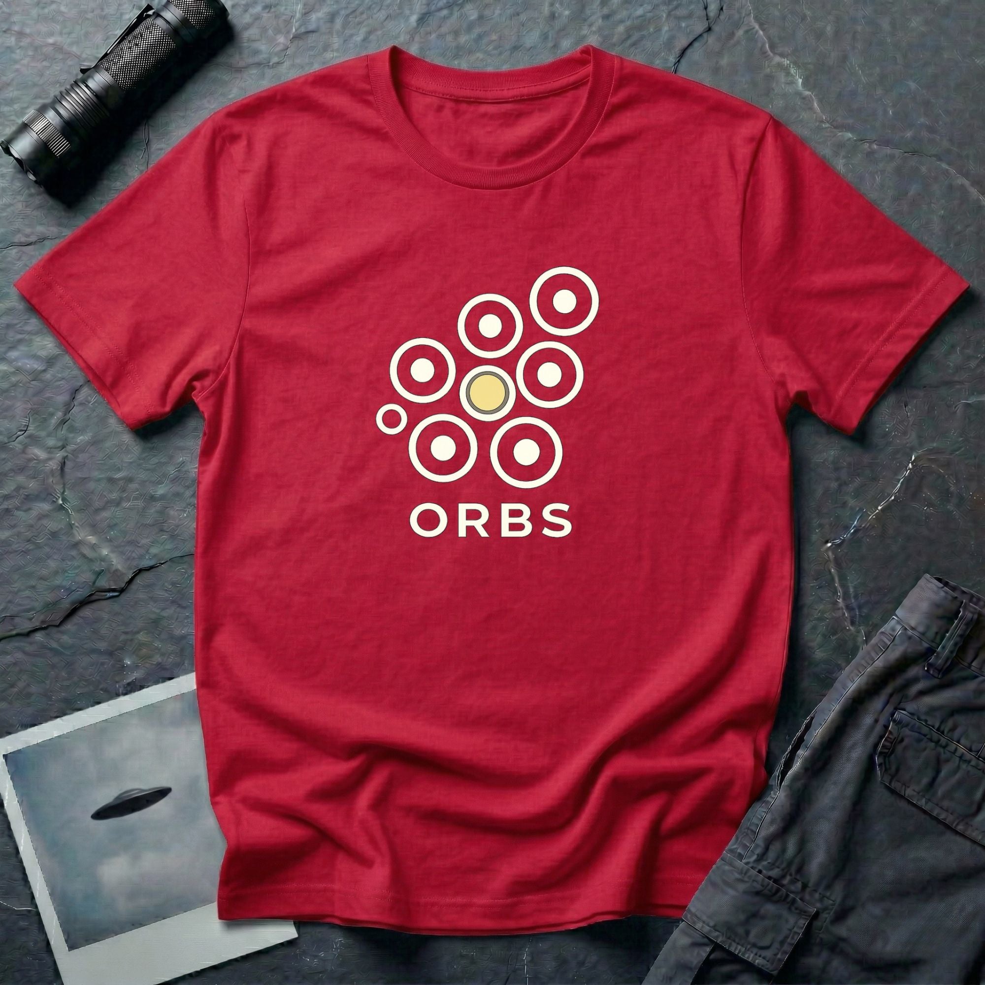 Orbs UFO t-shirt, seven ring-and-dot circles in a rosette pattern with one solid gold orb, above bold ORBS text, red