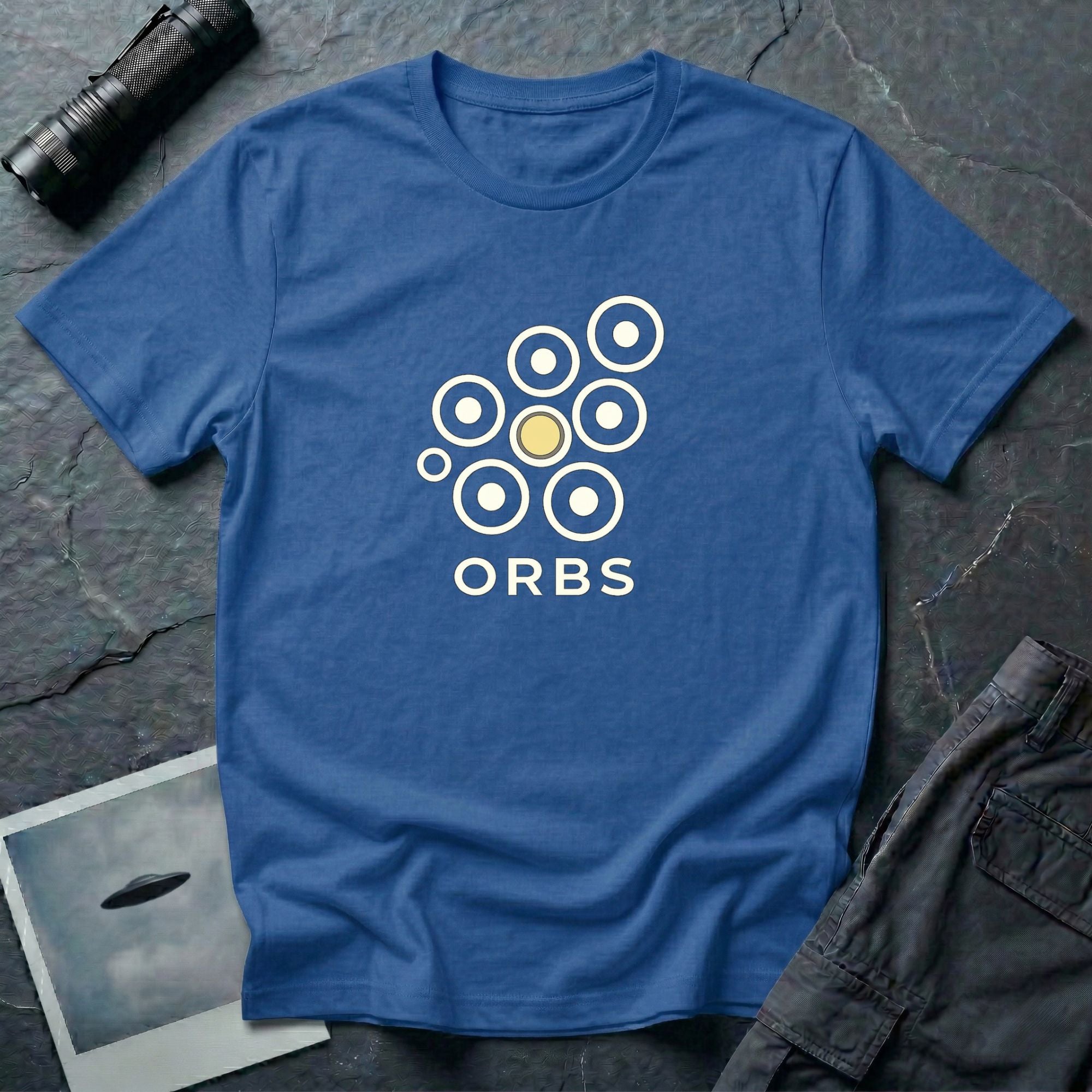 Orbs UFO t-shirt, seven ring-and-dot circles in a rosette pattern with one solid gold orb, above bold ORBS text, royal blue