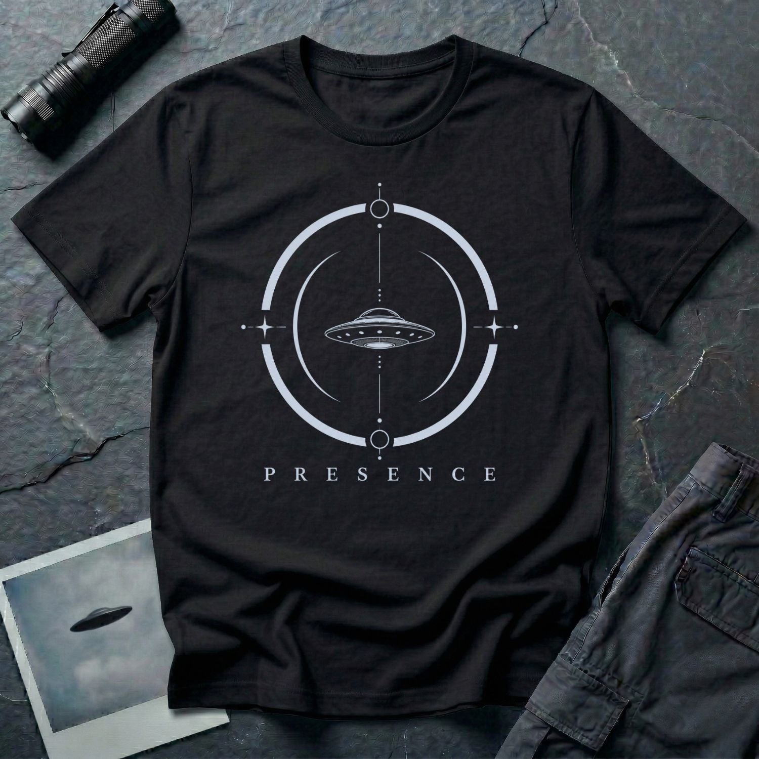 Black UFO t-shirt with a flying saucer inside a broken circular frame with the word PRESENCE beneath