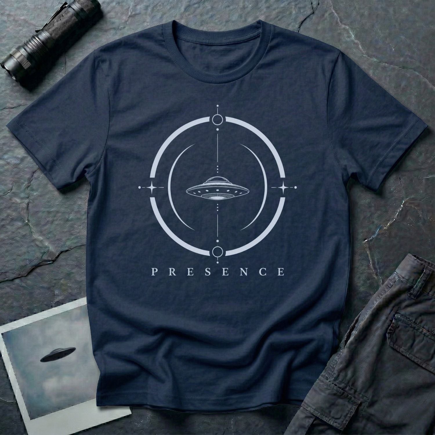 Navy blue UFO t-shirt with a flying saucer inside a broken circular frame with the word PRESENCE beneath