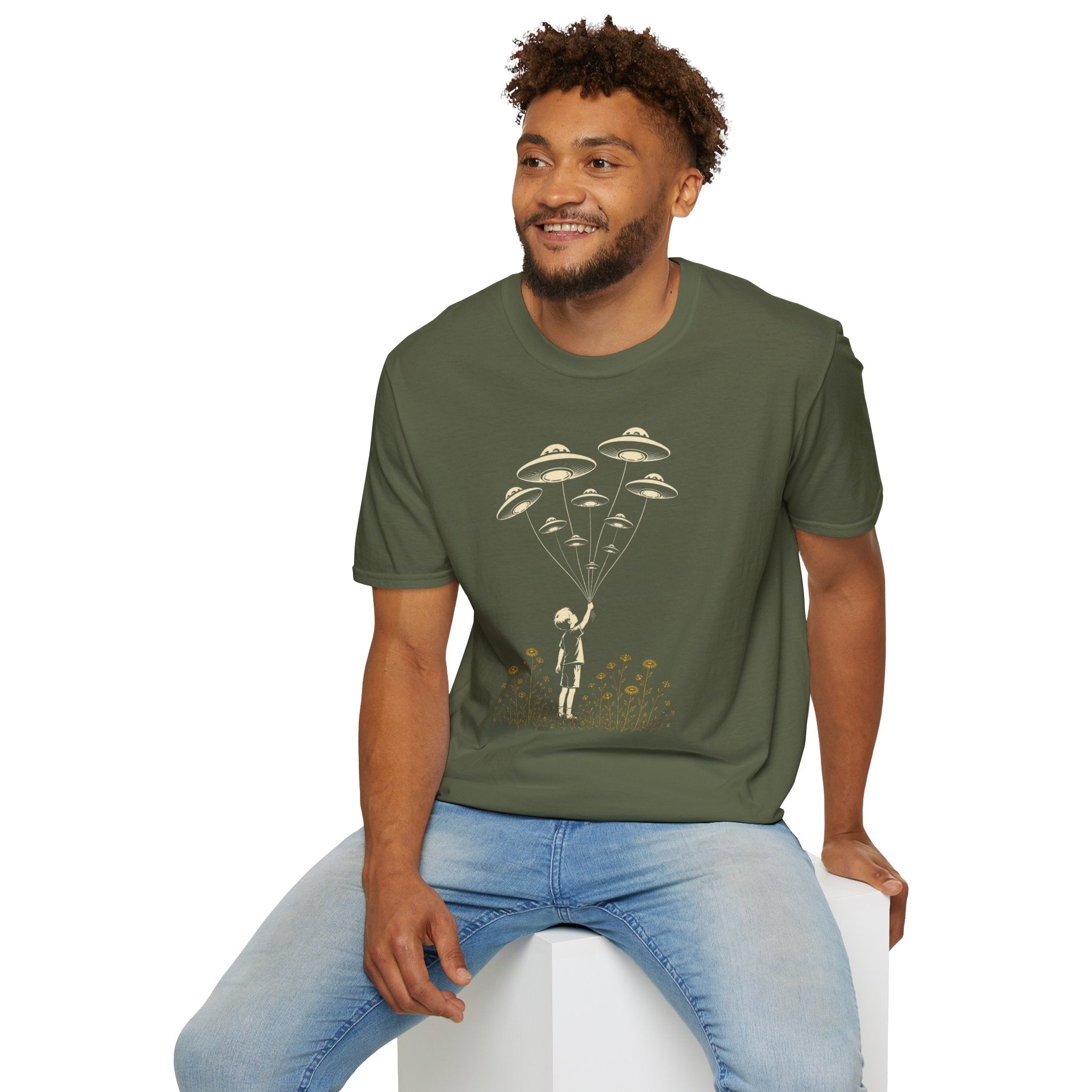 Stencil UFO t-shirt design, child reaching up to hold strings tethered to a small fleet of UFOs, orange wildflowers at the base, green tee