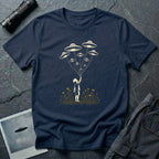 Stencil UFO t-shirt design, child reaching up to hold strings tethered to a small fleet of UFOs, orange wildflowers at the base, navy blue tee