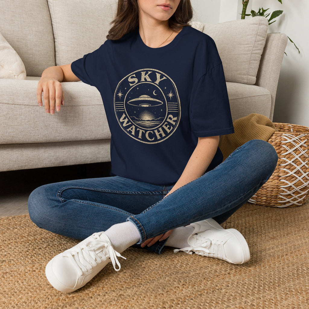 Model wearing navy blue retro UFO t-shirt with a distressed circular badge showing a flying saucer over water at night with a crescent moon and the words SKY WATCHER