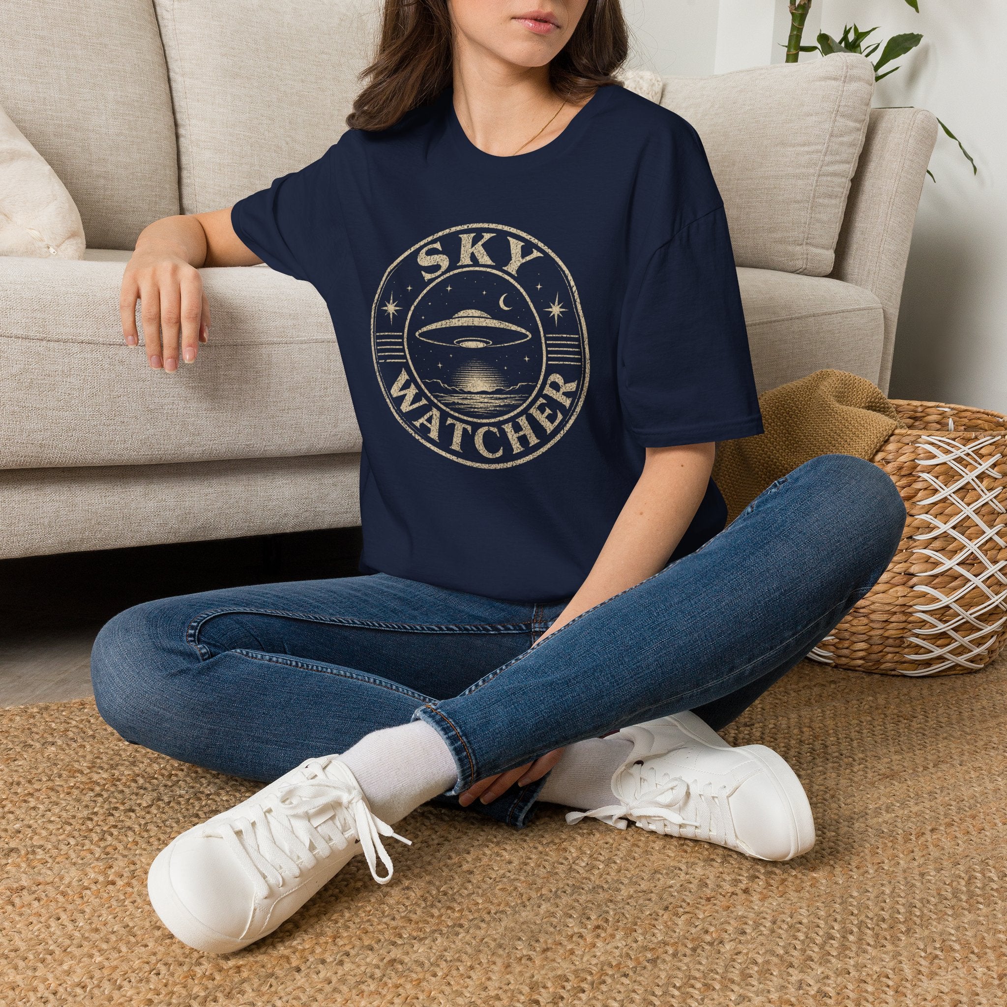 Model wearing navy blue retro UFO t-shirt with a distressed circular badge showing a flying saucer over water at night with a crescent moon and the words SKY WATCHER