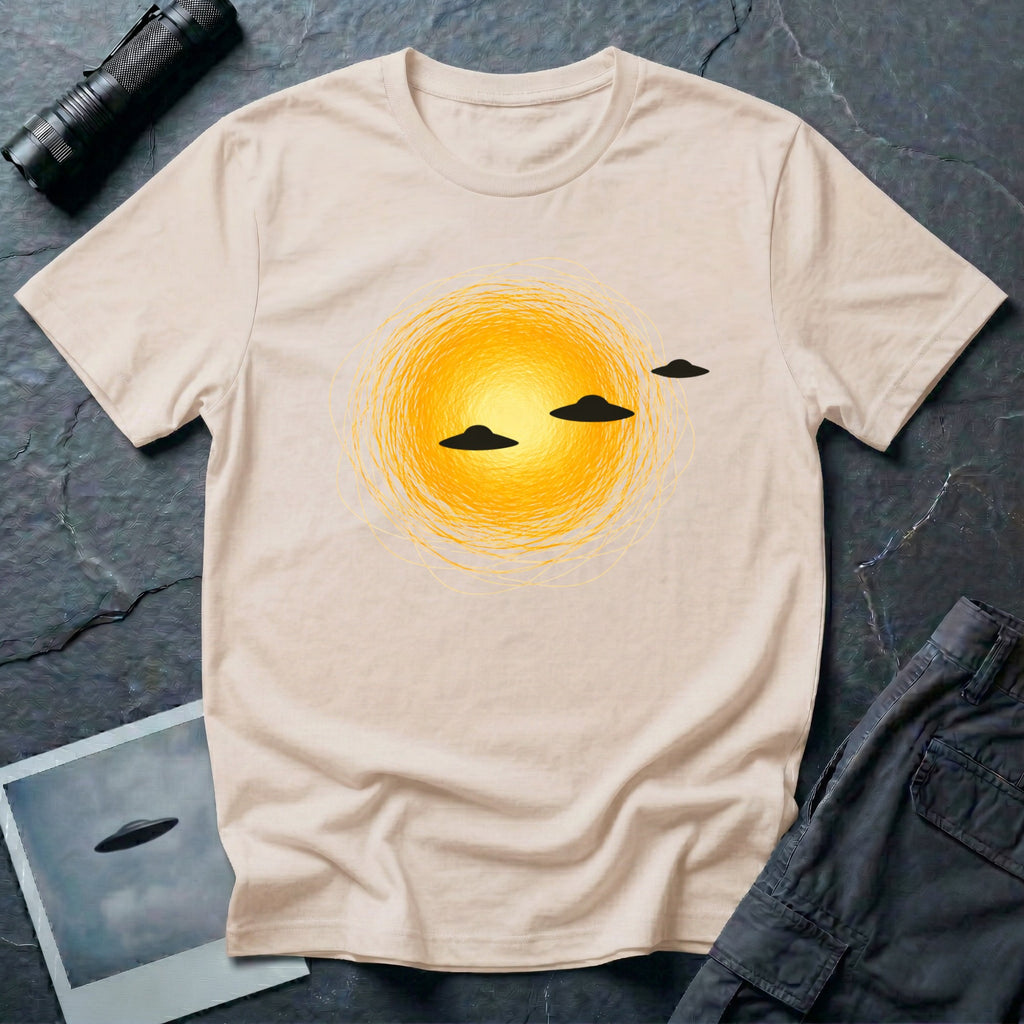 Solar Fly-by artistic UFO t-shirt — three black flying saucers passing across a glowing sun on natural unisex cotton tee