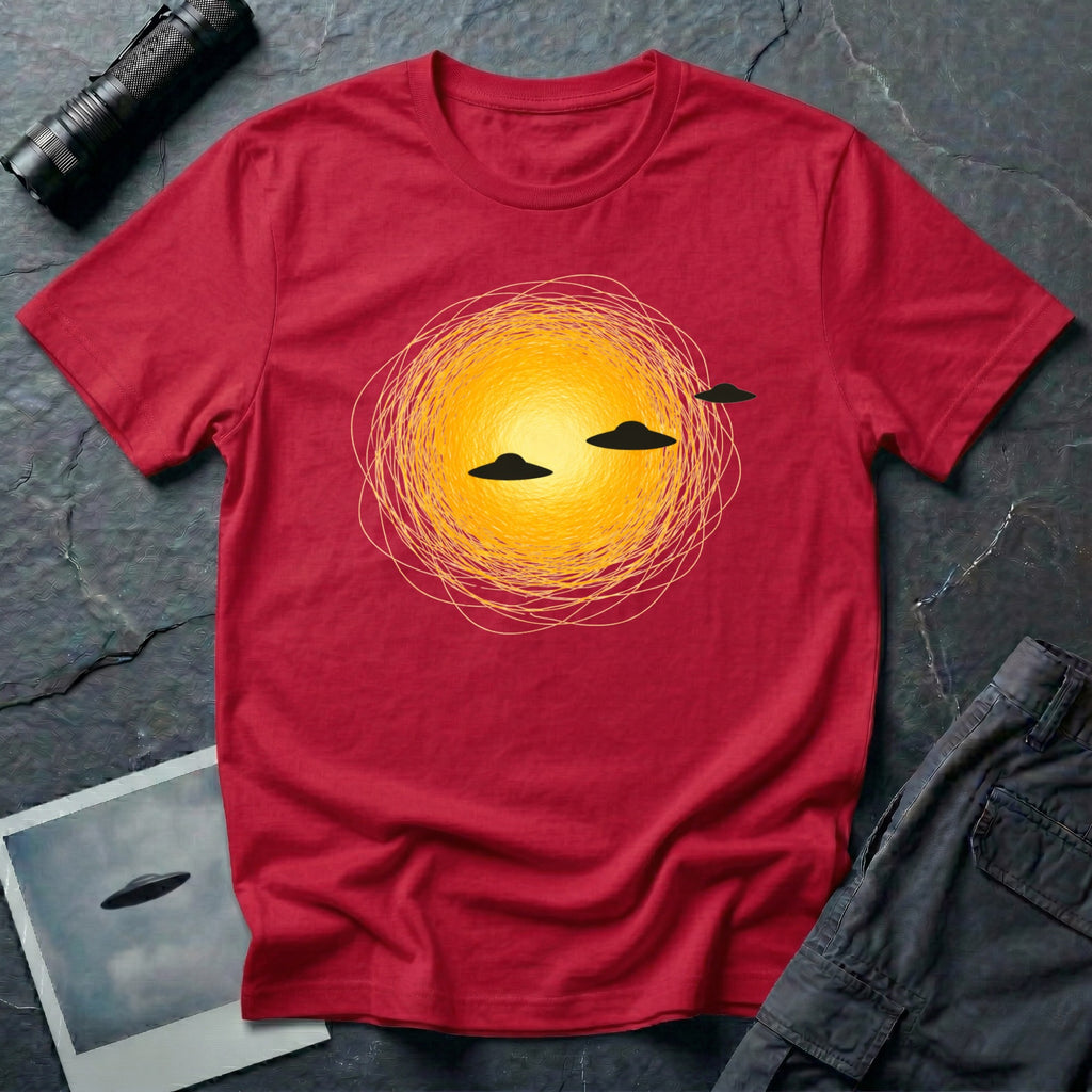 Solar Fly-by artistic UFO t-shirt — three black flying saucers passing across a glowing sun on red unisex cotton tee