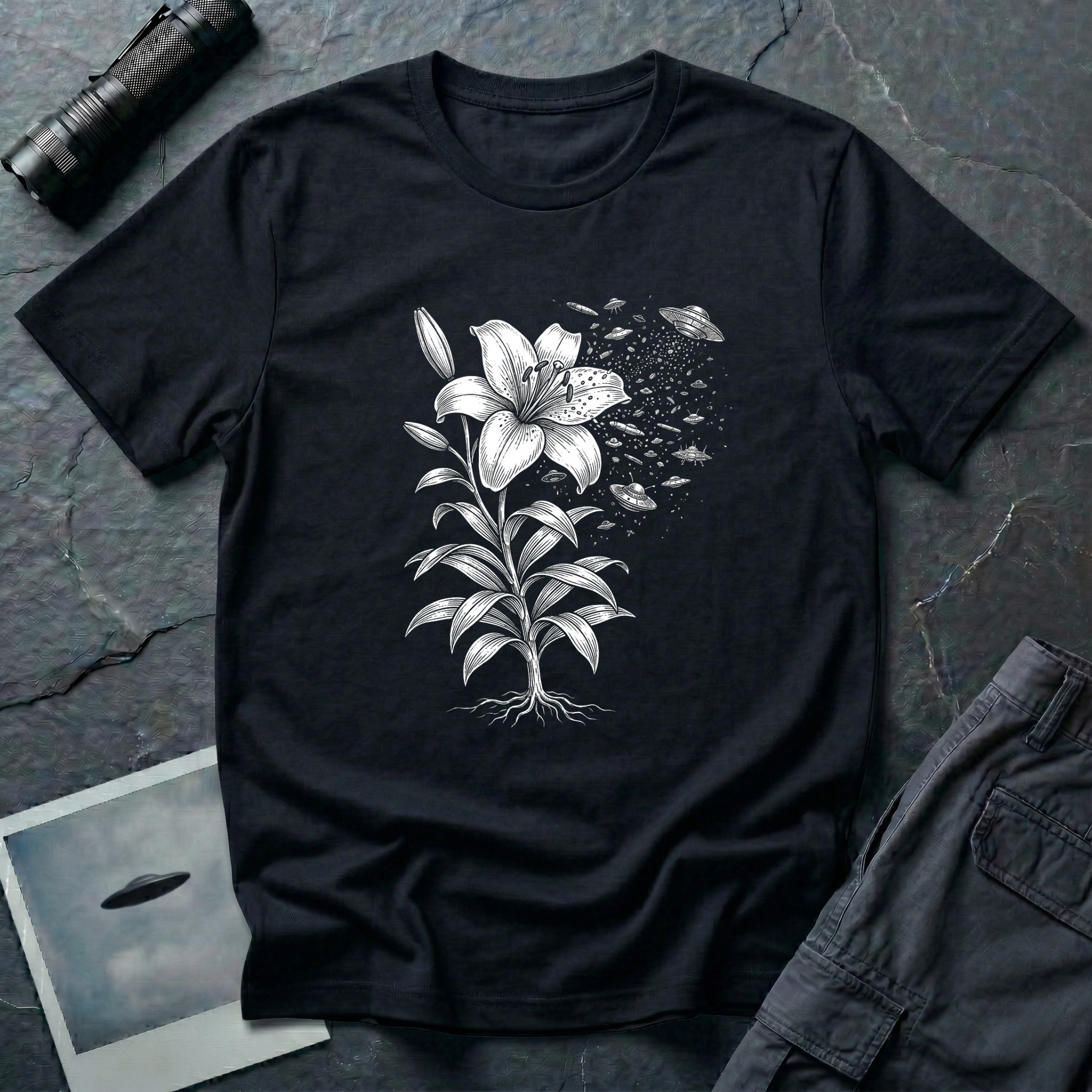 Space Lily surreal UFO art t-shirt — Victorian botanical lily illustration dissolving into flying saucers in white linework on black cotton tee