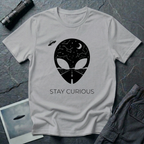 Stay Curious curious alien t-shirt — alien silhouette filled with starry sky above and open highway below with "Stay Curious" on grey cotton tee