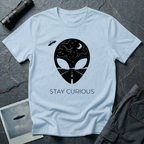 Stay Curious curious alien t-shirt — alien silhouette filled with starry sky above and open highway below with "Stay Curious" on light blue cotton tee