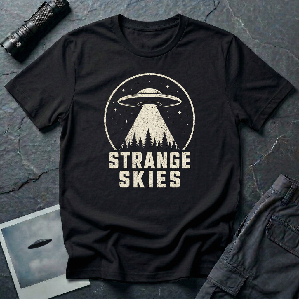 Black retro UFO t-shirt with a flying saucer and tractor beam over a conifer forest inside a distressed circle with the words STRANGE SKIES in white